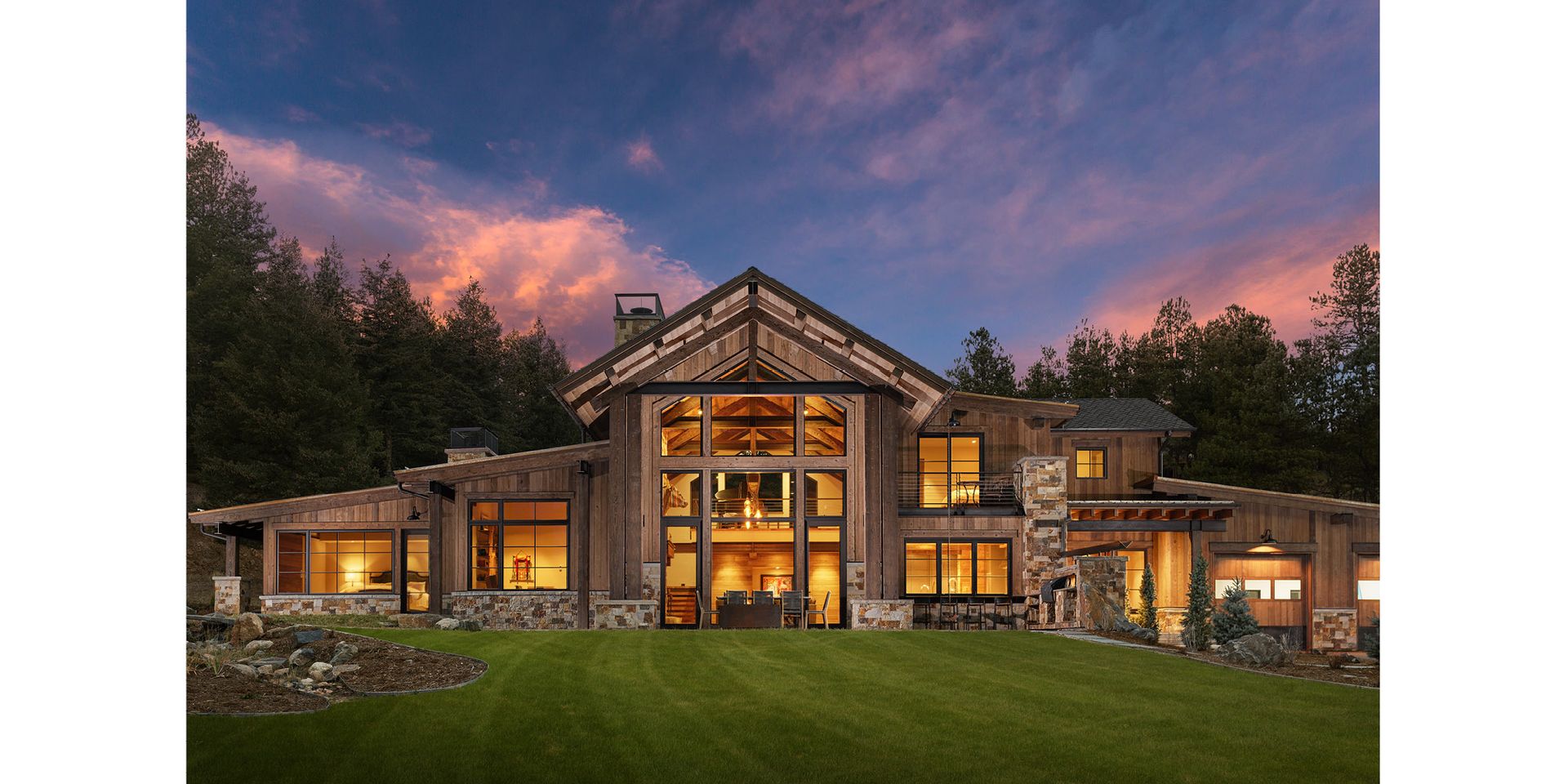 A large house with a lot of windows is lit up at night.