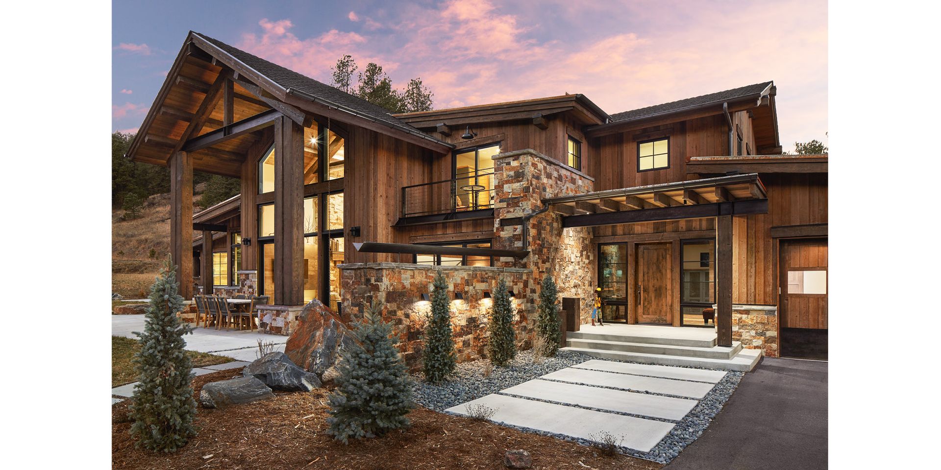 A large wooden house with a lot of windows is sitting on top of a hill.