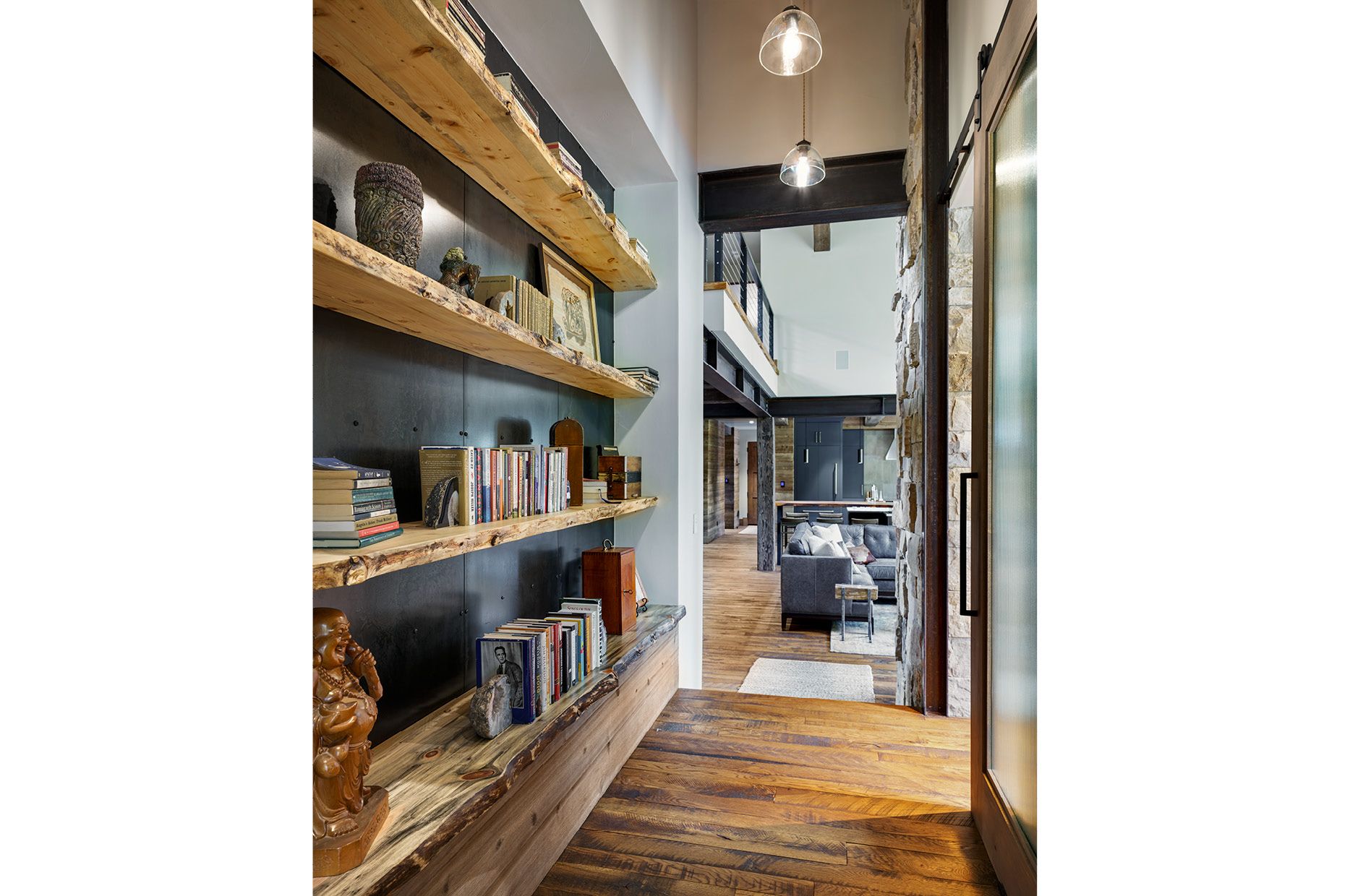 A hallway with wooden shelves and a living room in the background.