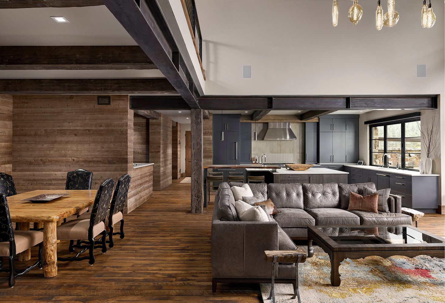 A living room with a couch , table , chairs and a kitchen.
