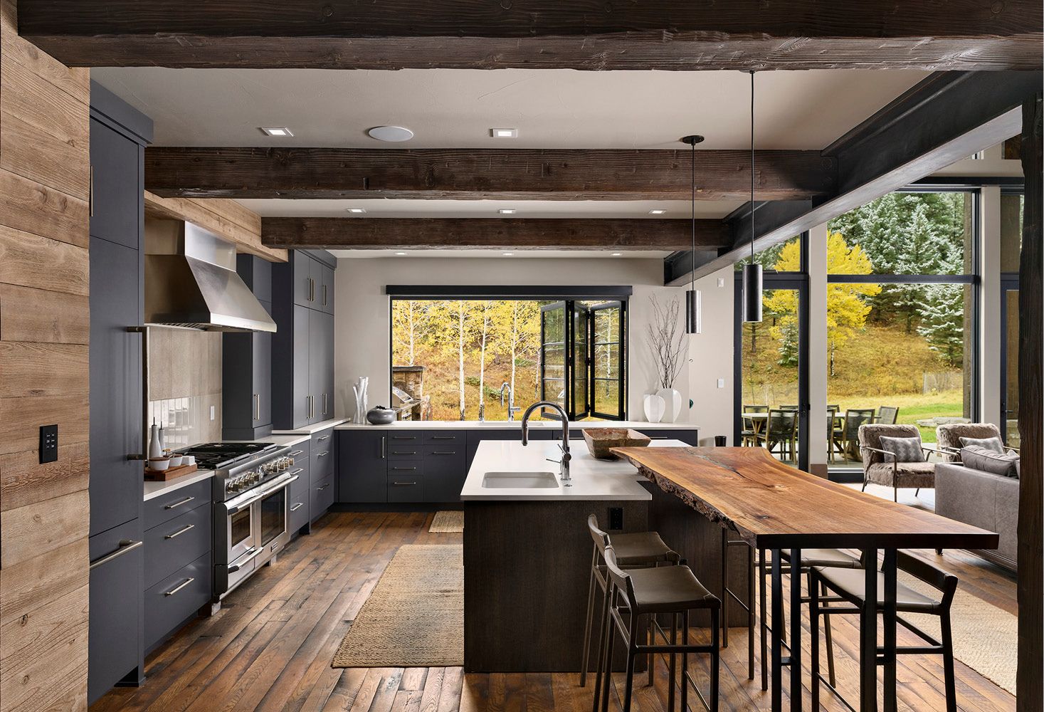 A kitchen with a large island and a wooden table.