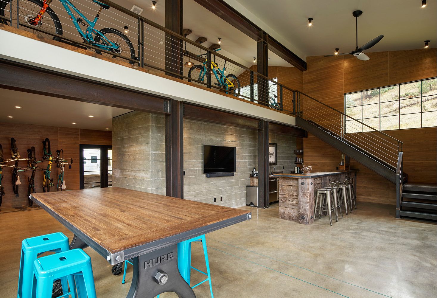 A large room with a wooden table and blue stools.