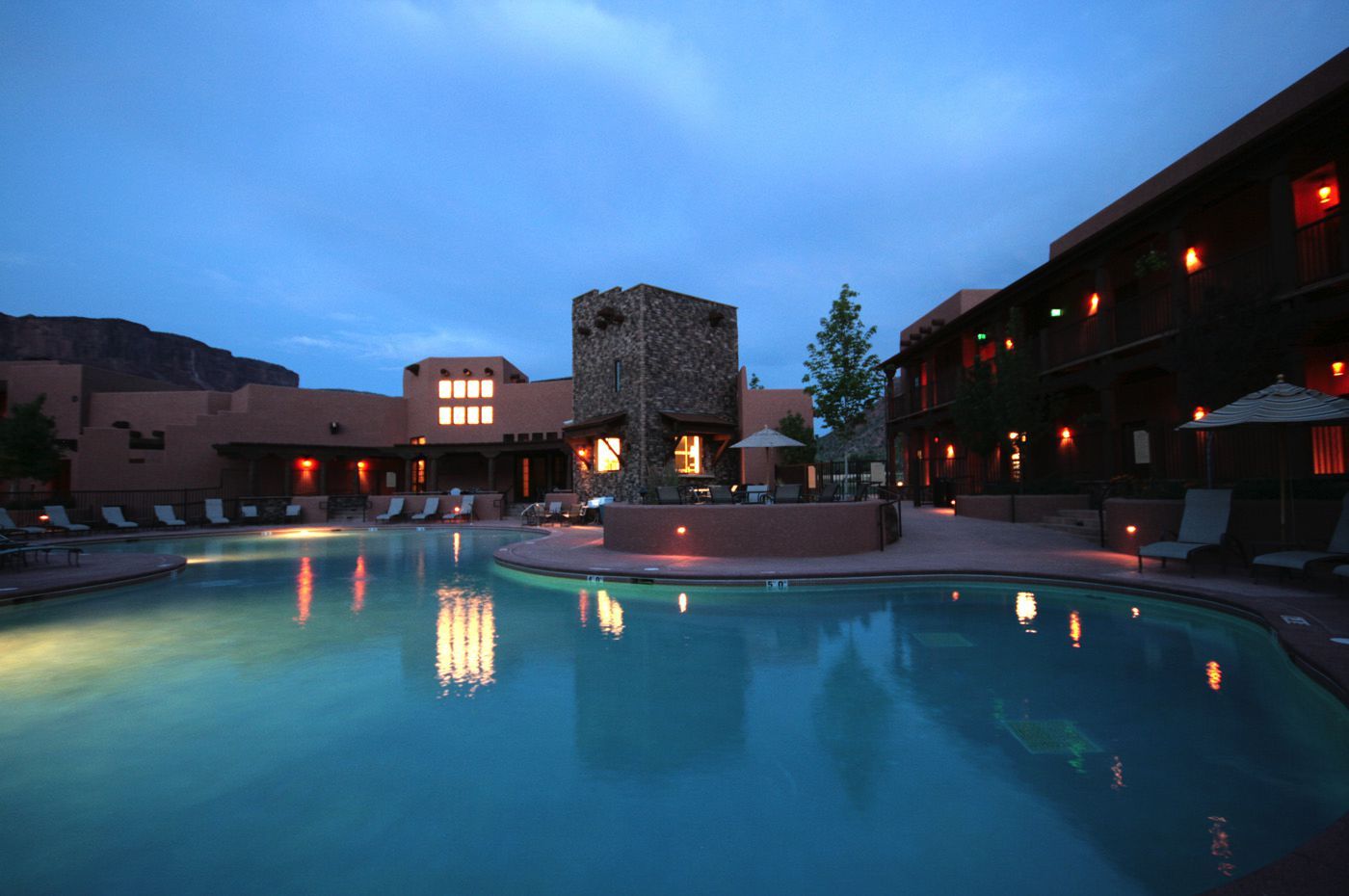 A large swimming pool in front of a hotel at night