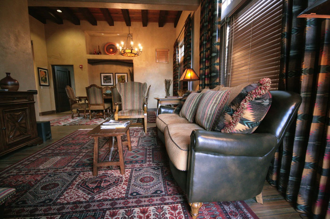 A living room with a couch and chairs and a rug