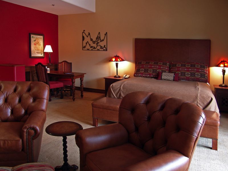 A hotel room with a large bed and chairs