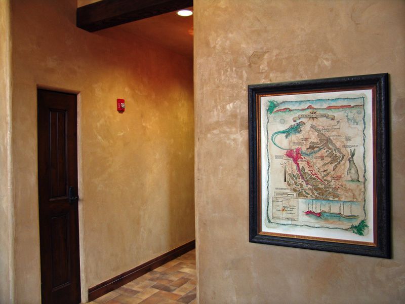 A picture of a map is hanging on a wall in a hallway.