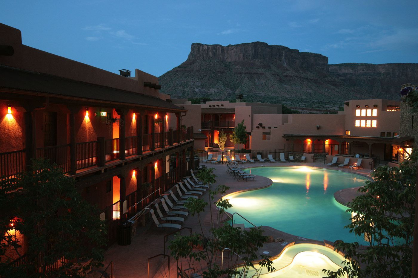 A hotel with a swimming pool and a mountain in the background