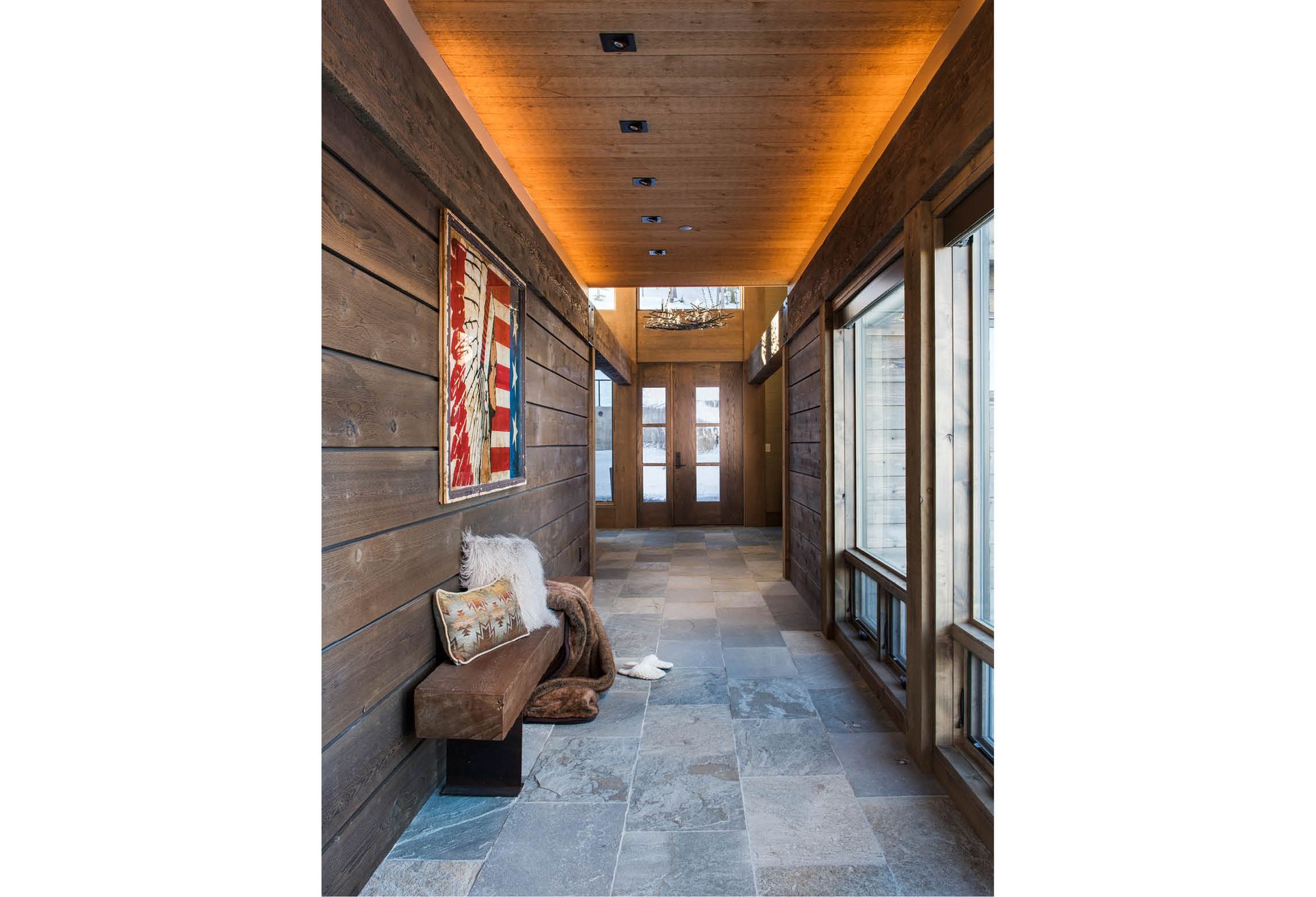 A long hallway with wooden walls and a bench in the middle.