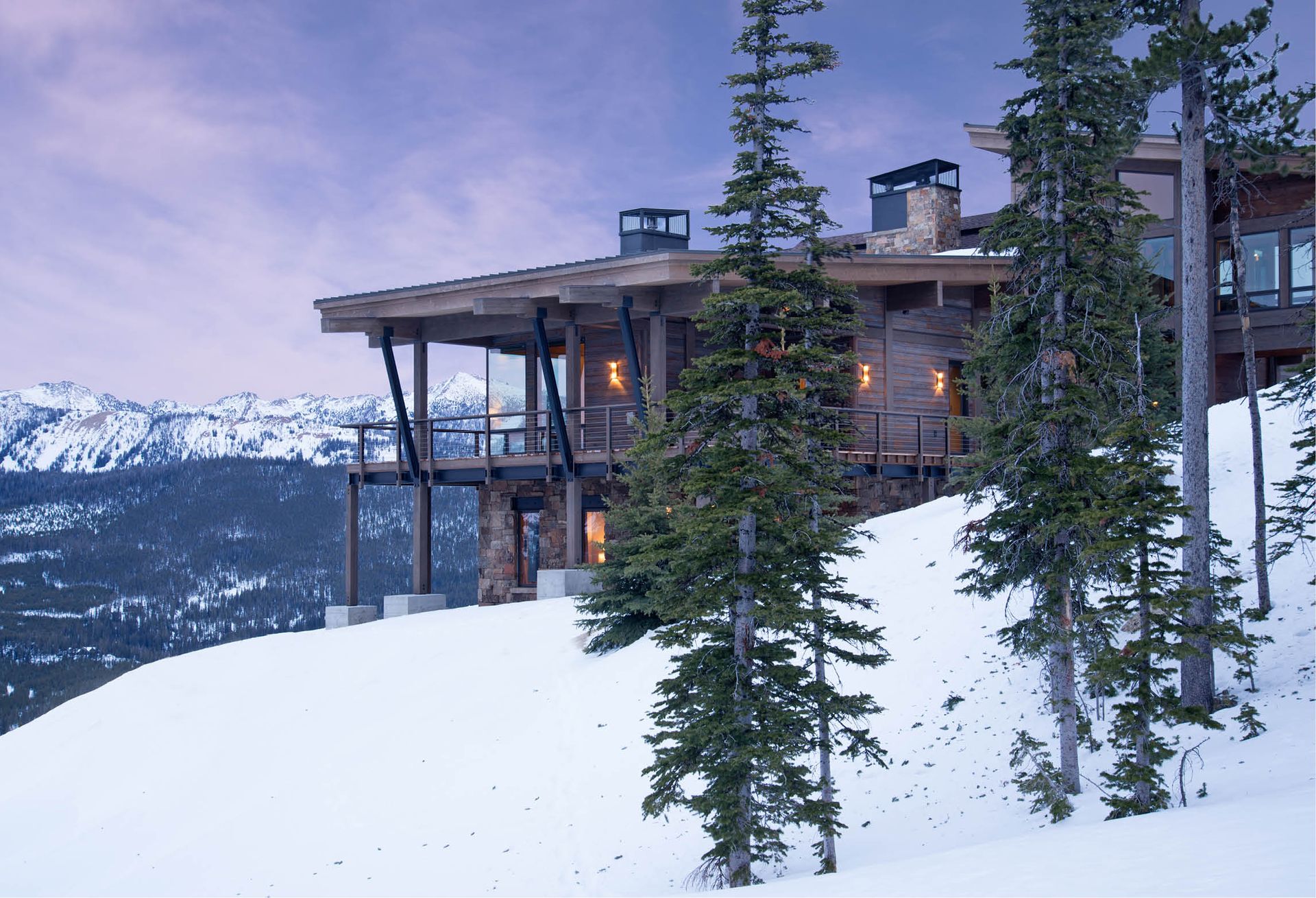 A large house sits on top of a snow covered hill