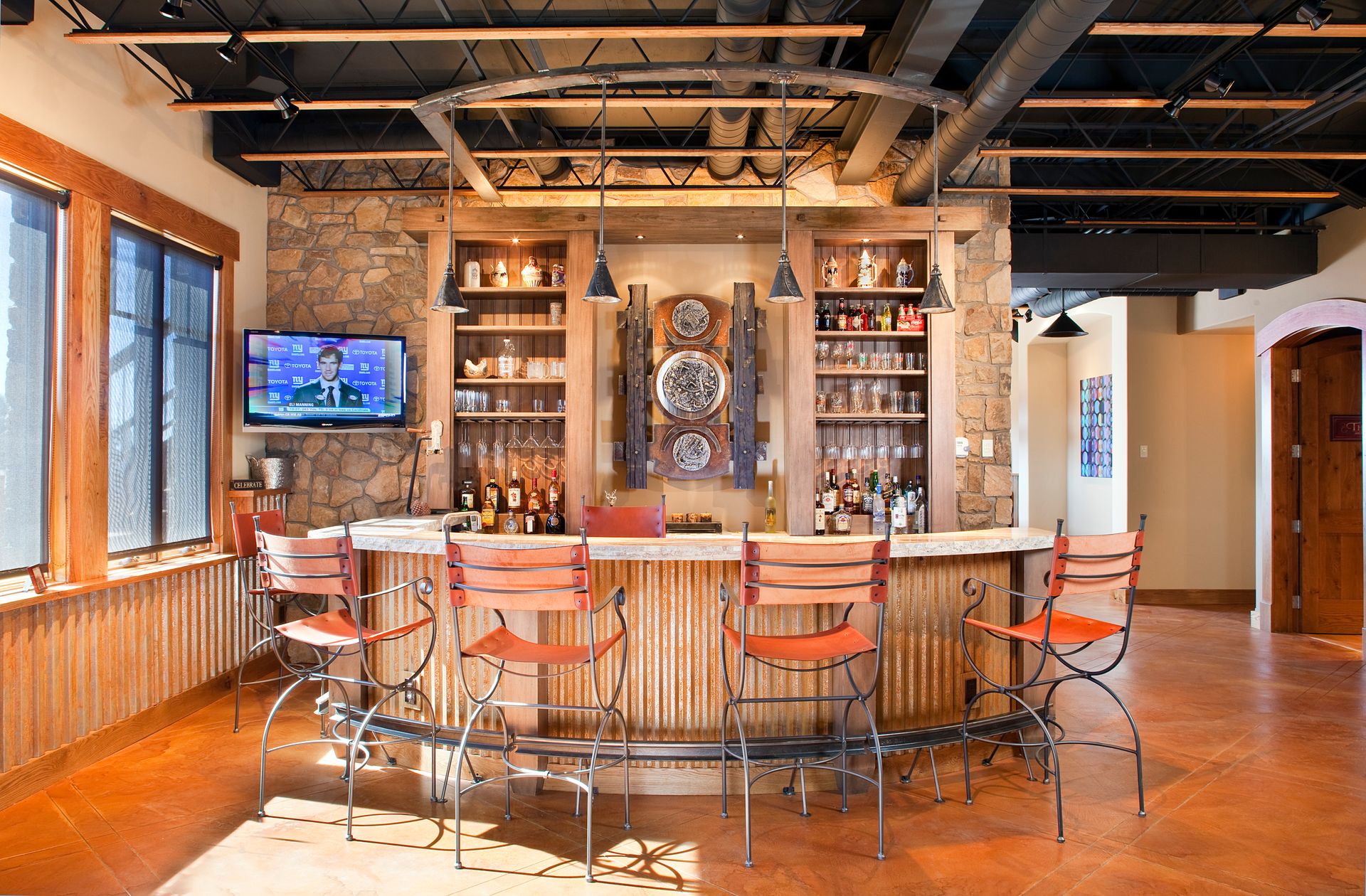 A large room with a bar and chairs in it