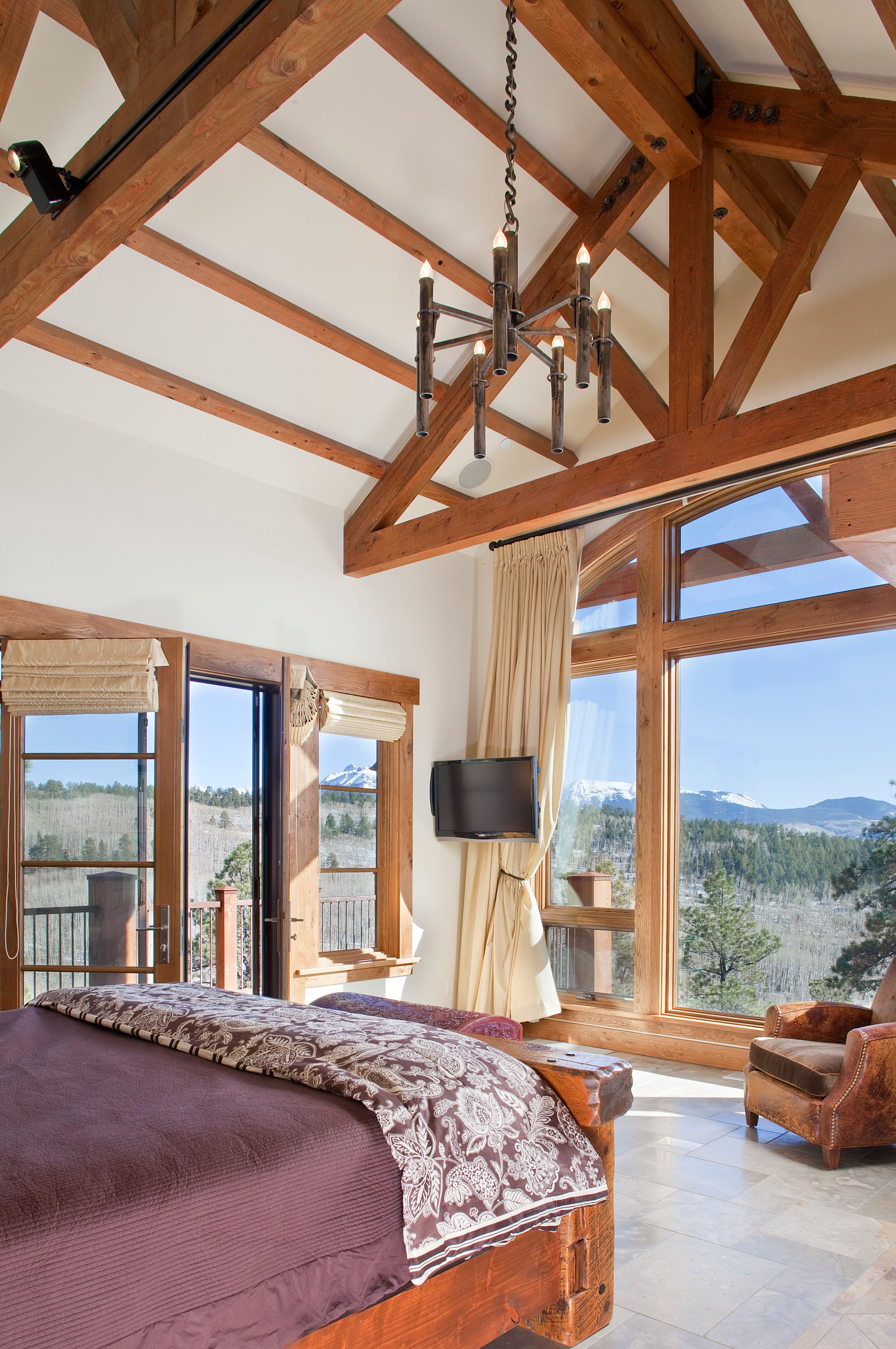 A bedroom with a large bed and lots of windows