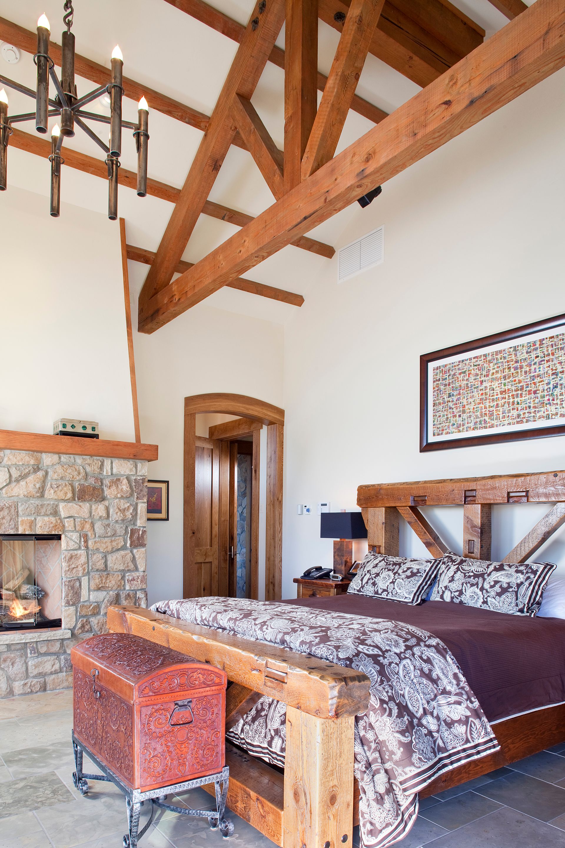 A bedroom with a large bed and a fireplace