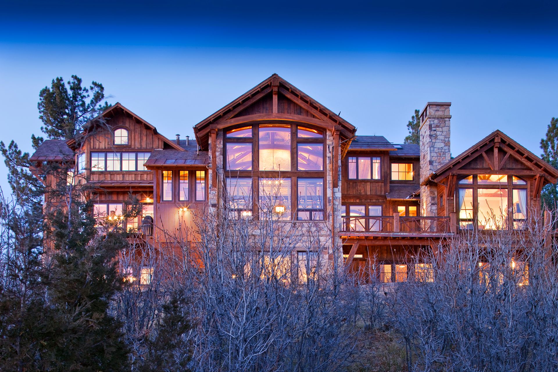 A large house with a lot of windows is sitting on top of a hill.