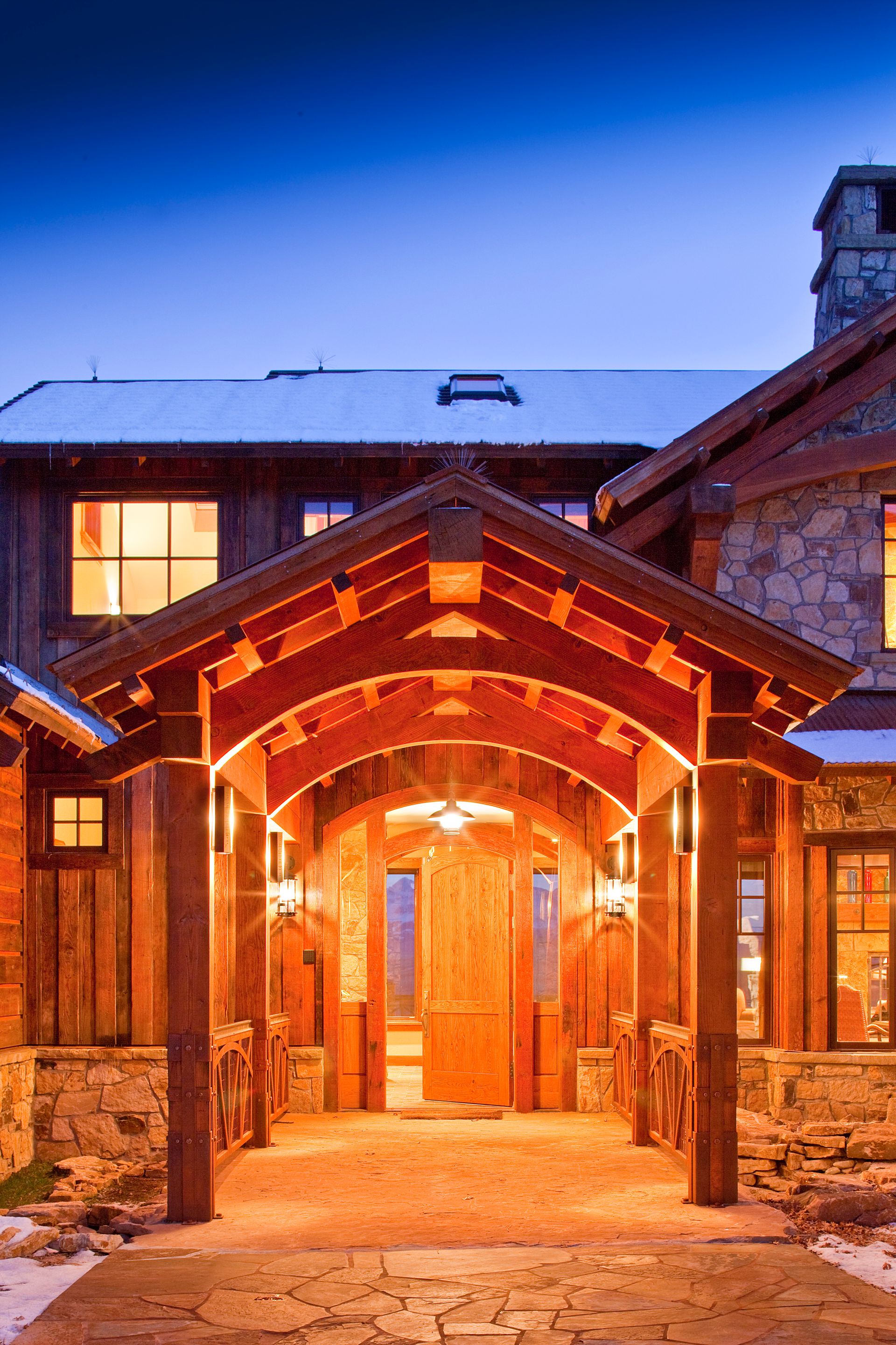 A large house with a wooden porch and a stone wall