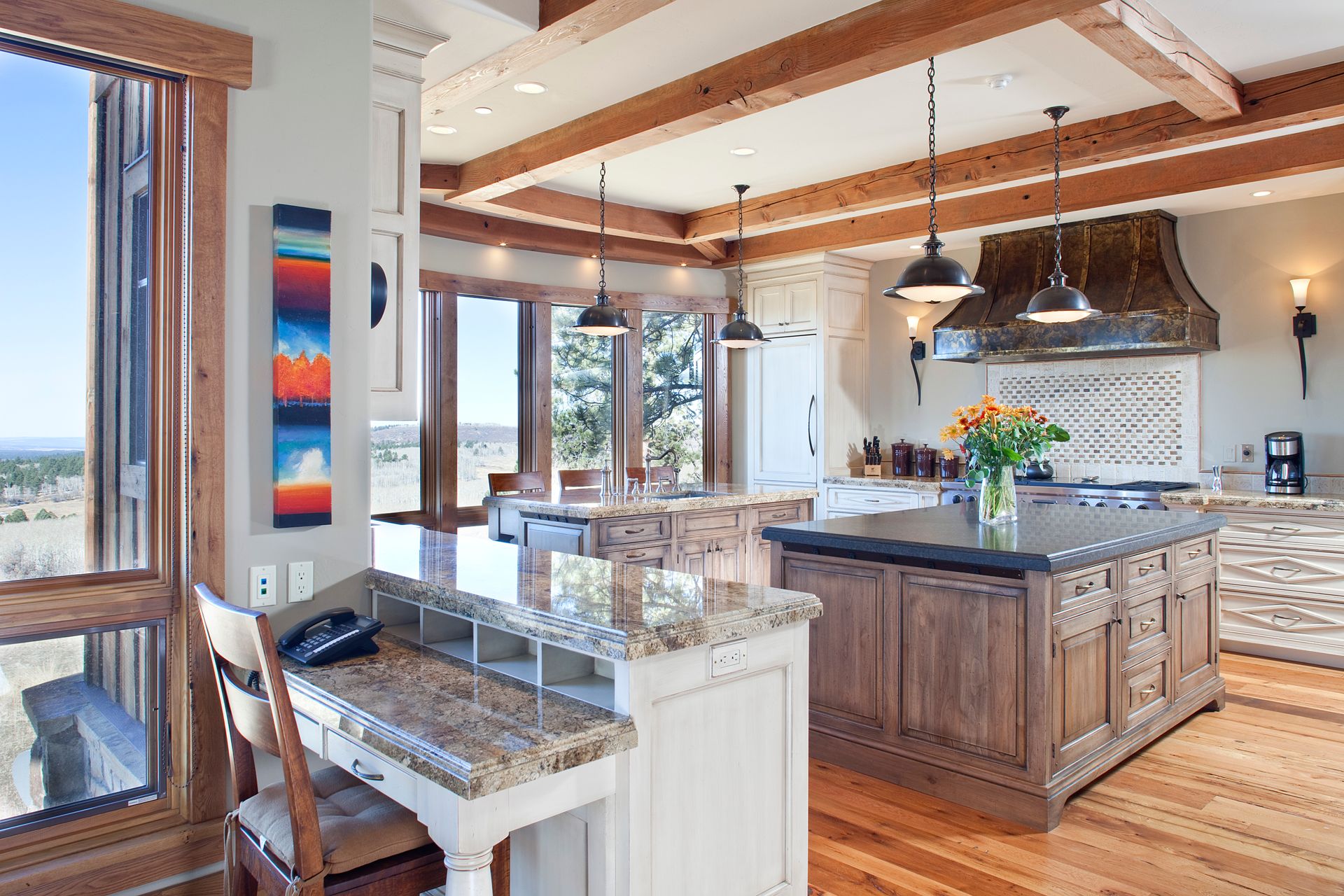 A kitchen with a large island and a desk with a phone on it