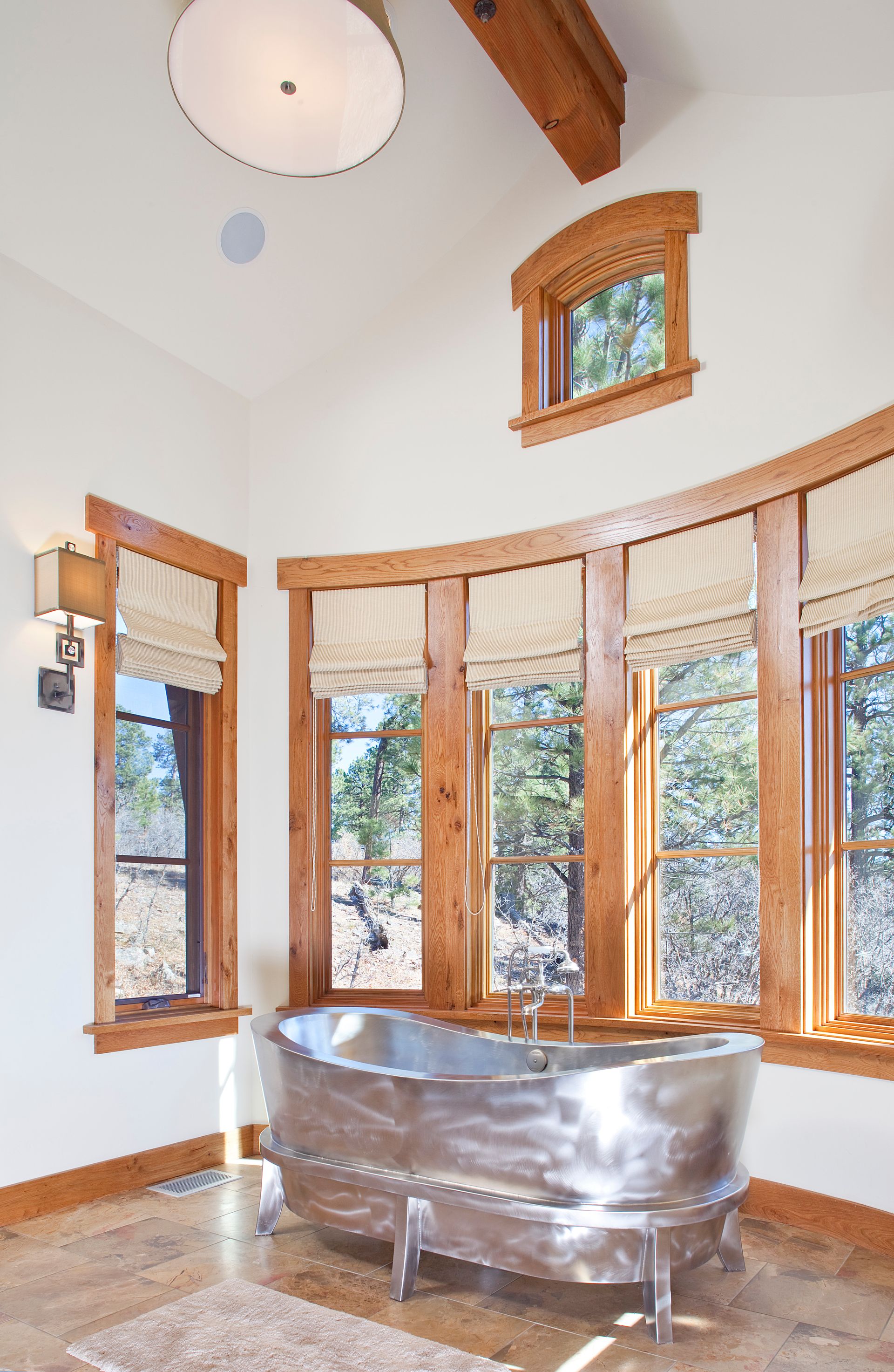 A bathtub in a bathroom with lots of windows
