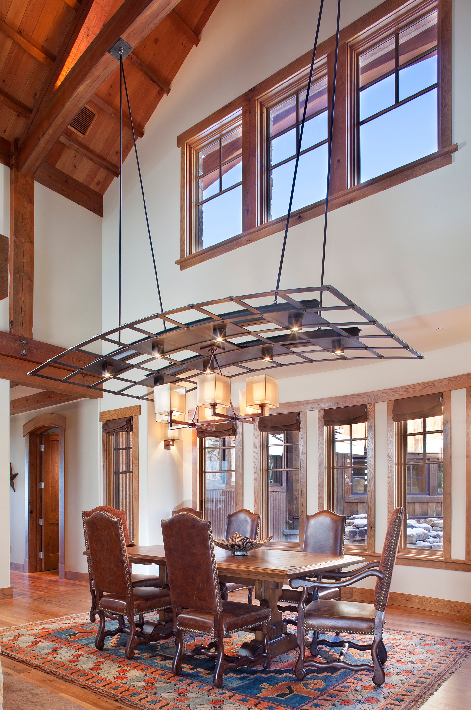 A dining room with a table and chairs and a chandelier hanging from the ceiling