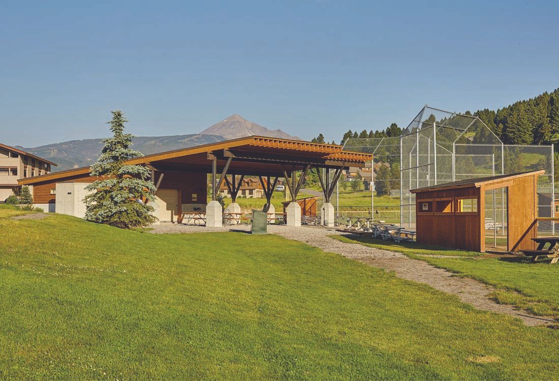 There is a greenhouse in the middle of a grassy field.