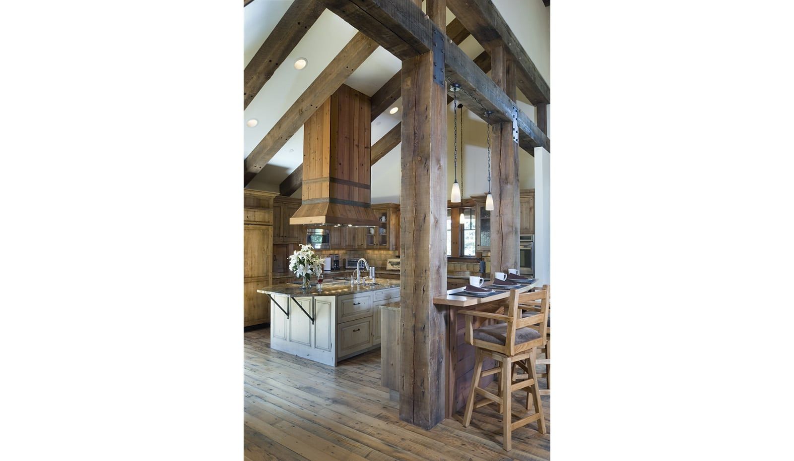 A kitchen with wooden beams and stools in it