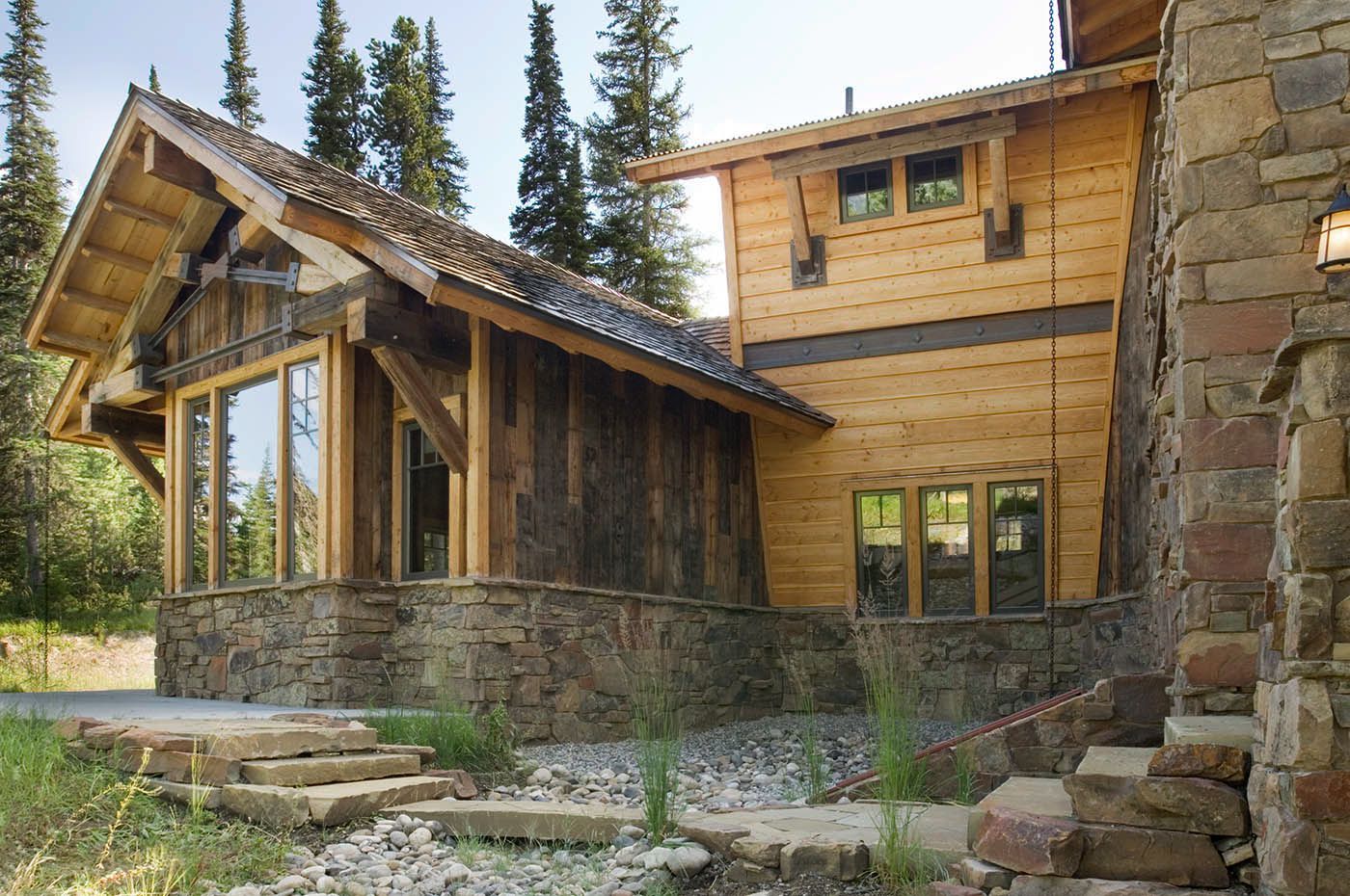 A wooden house with a stone wall and stairs leading up to it
