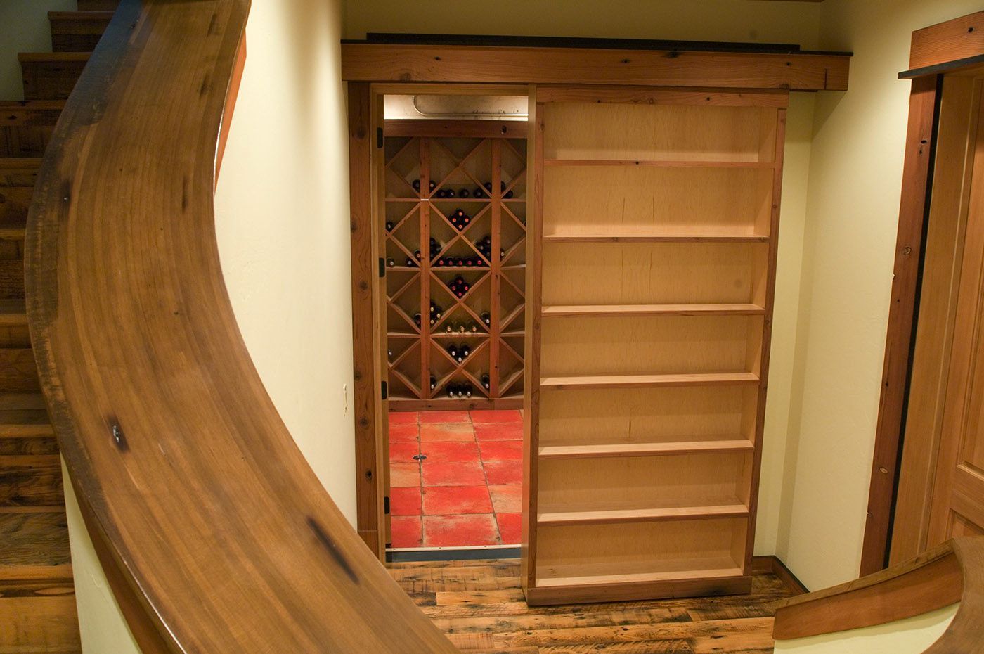 A staircase leading to a wine cellar with a sliding door
