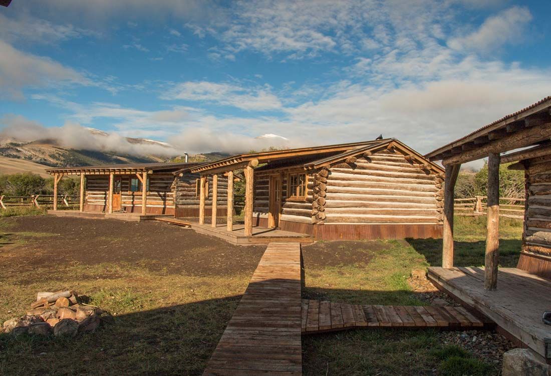 A group of log cabins sitting next to each other in a field.