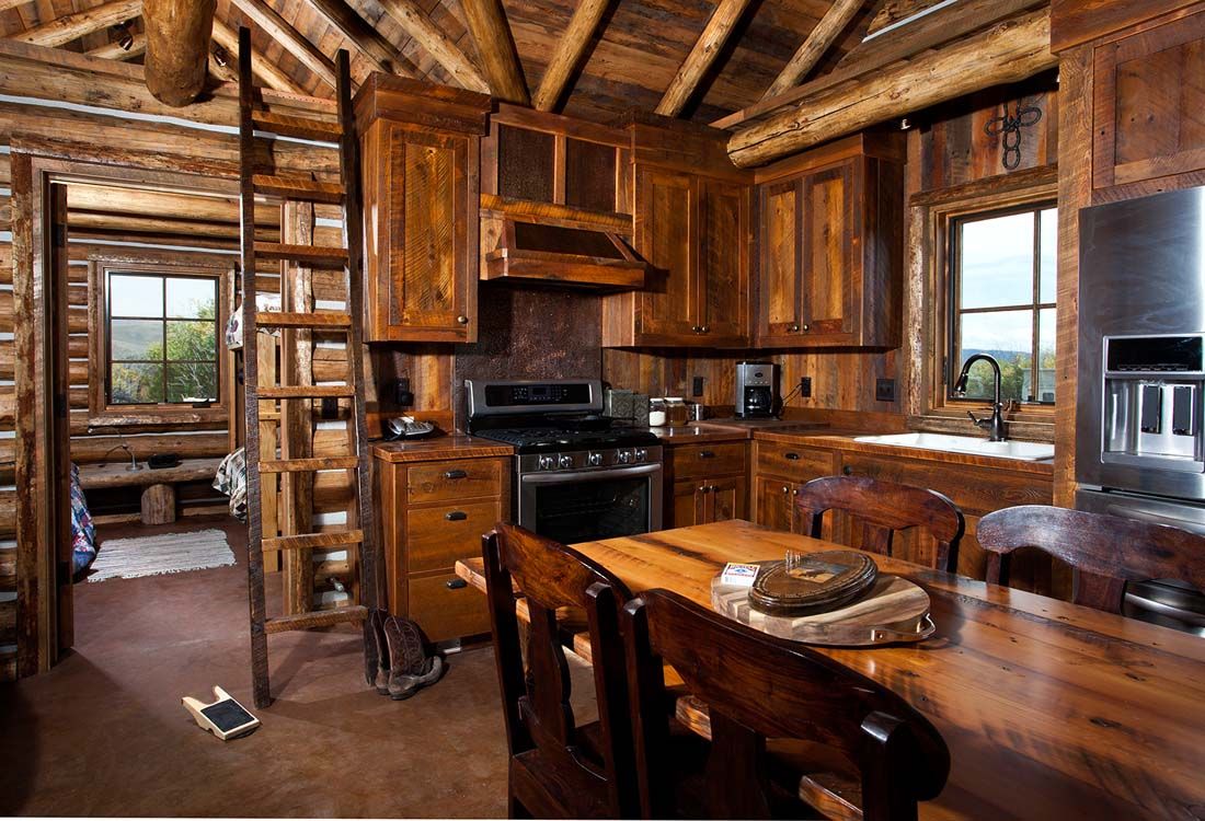 A kitchen in a log cabin with wooden cabinets and stainless steel appliances