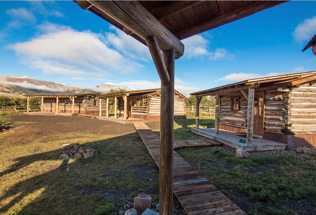A group of log cabins sitting next to each other in a field.