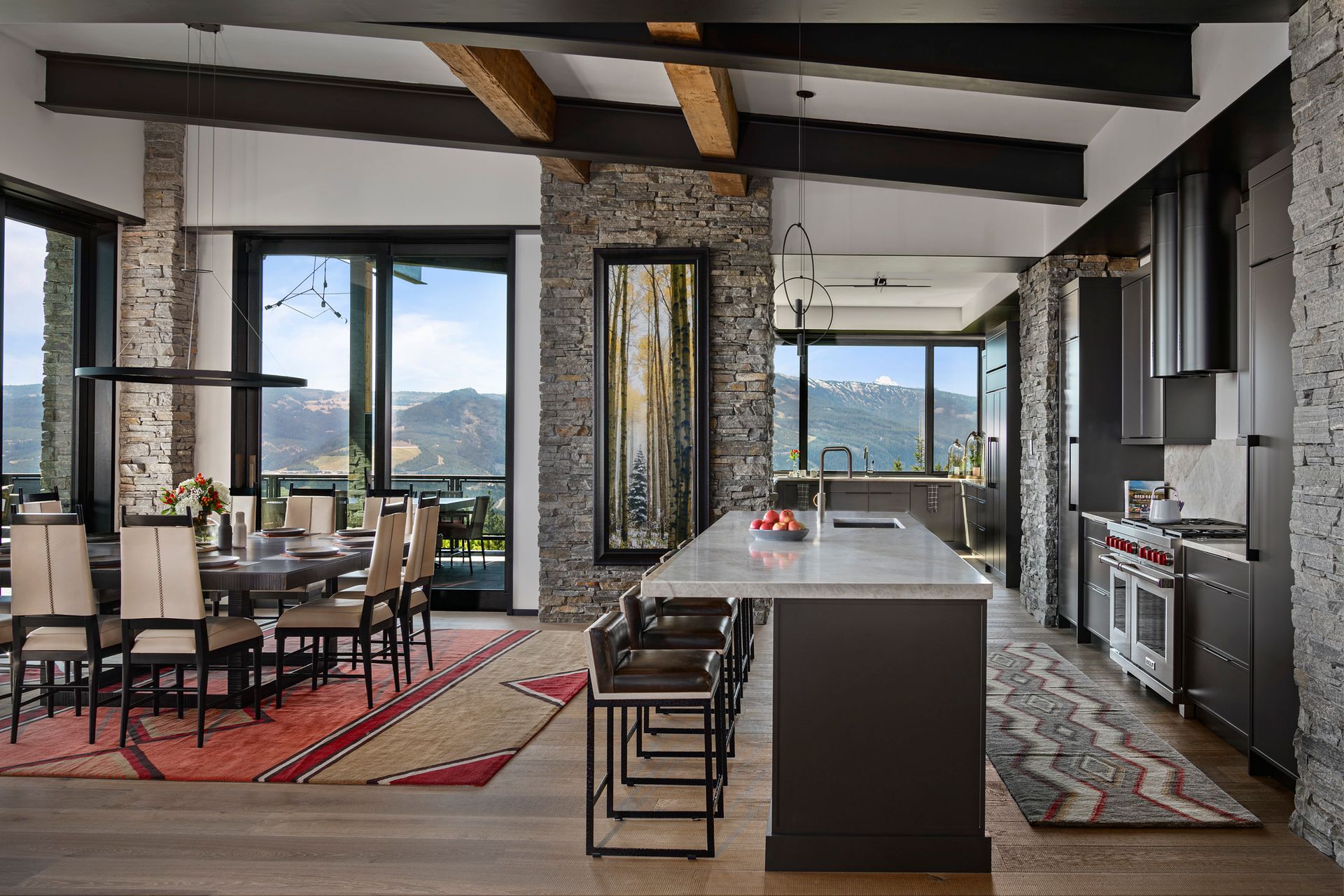 A kitchen and dining room in a house with a large island in the middle.