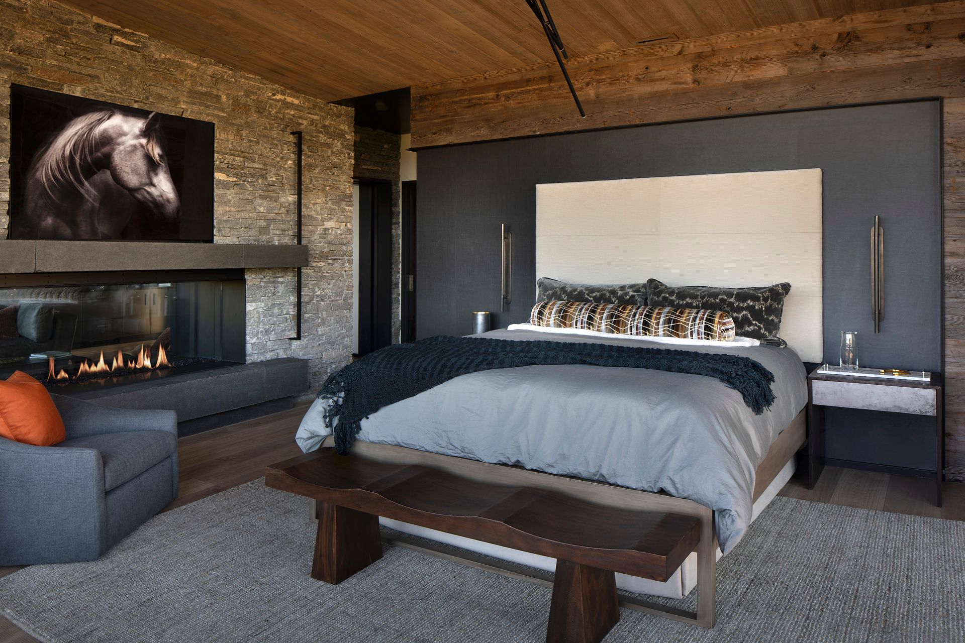 A bedroom with a large bed and a fireplace