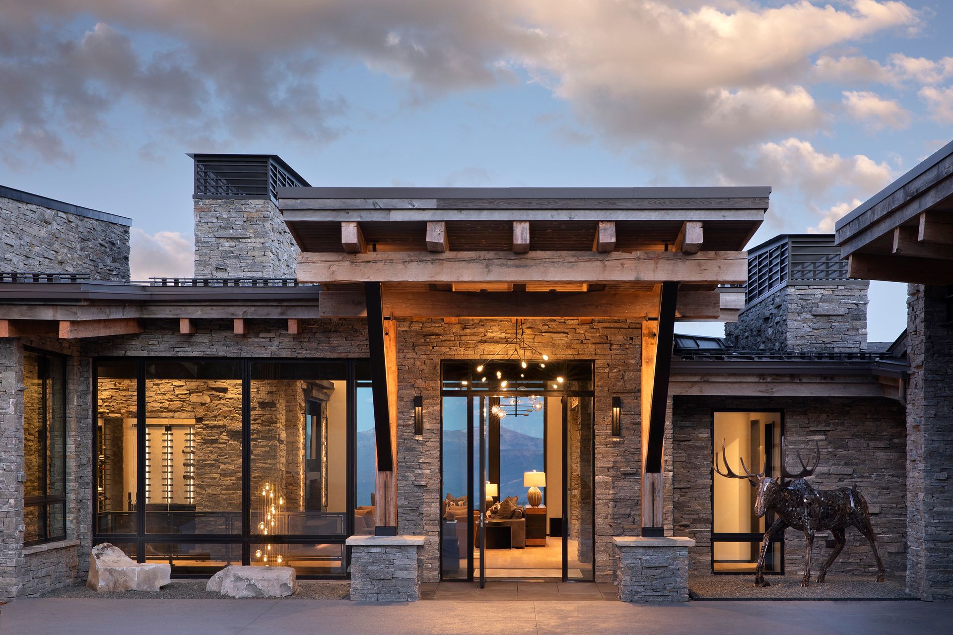 A large stone house with a horse statue in front of it