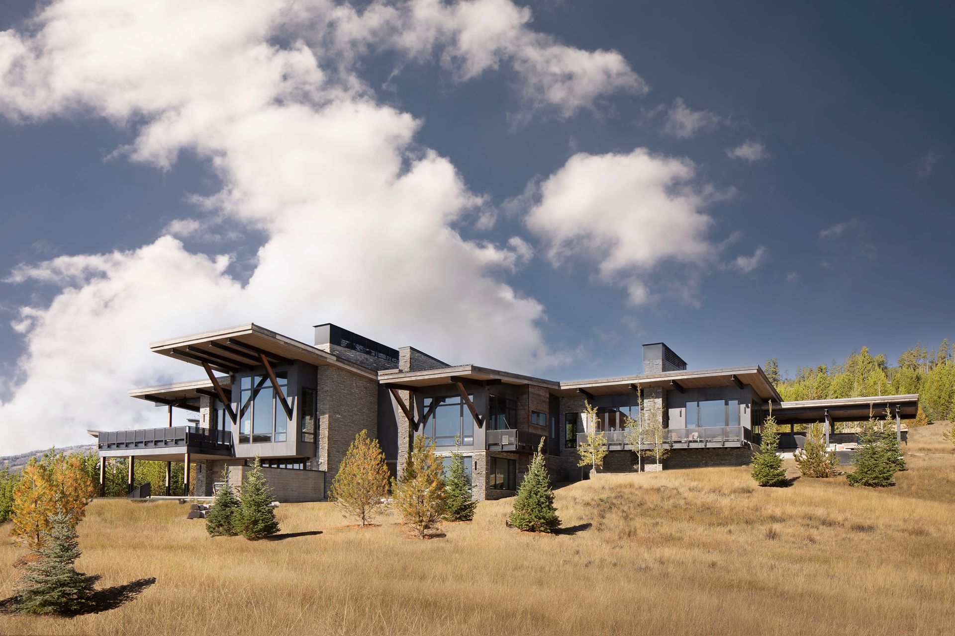 A large house is sitting on top of a hill in the middle of a field.