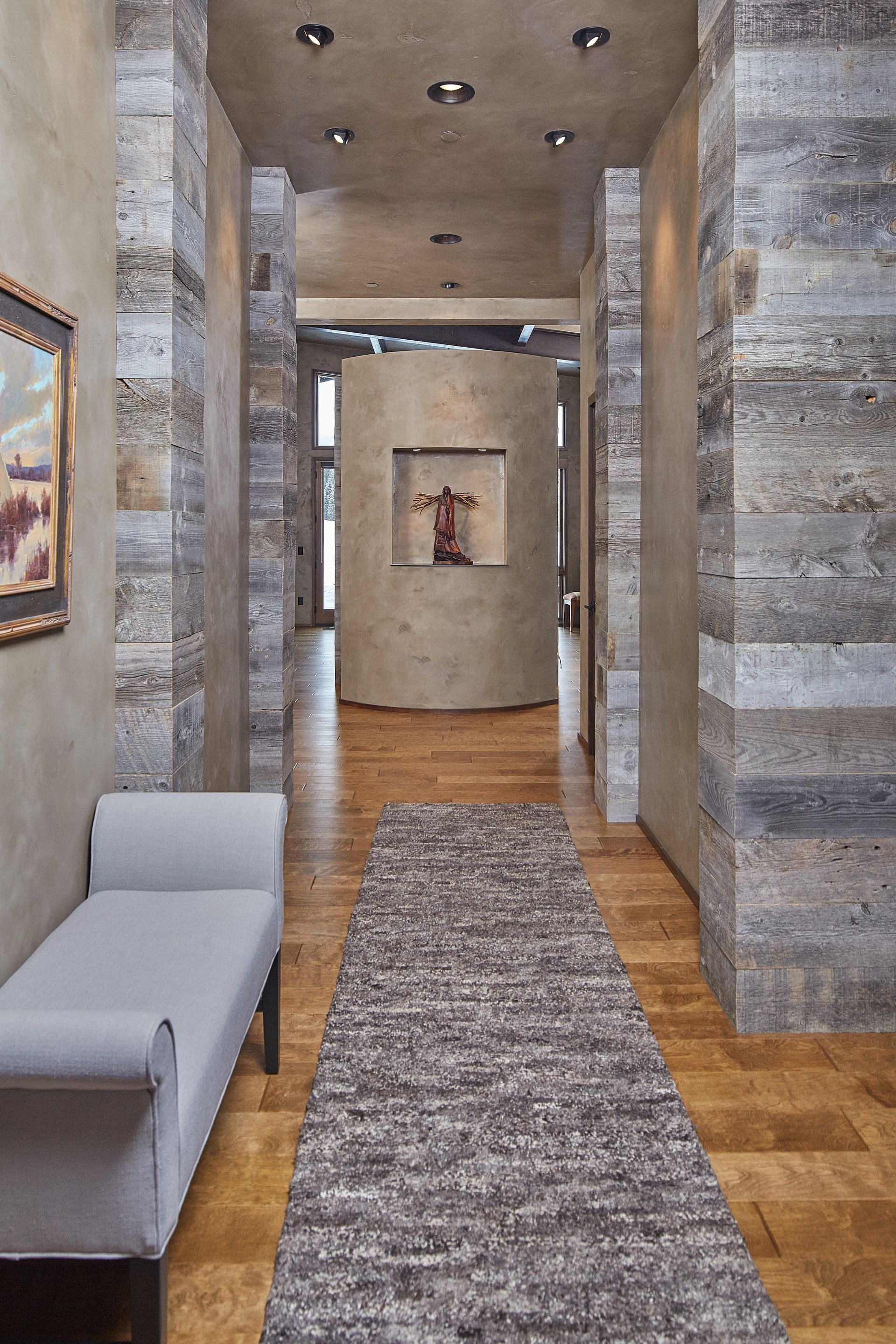 A hallway with a bench and a rug in it