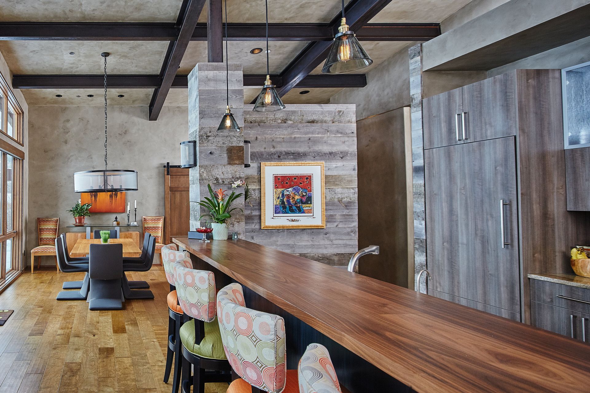 A kitchen with a wooden counter top and chairs.