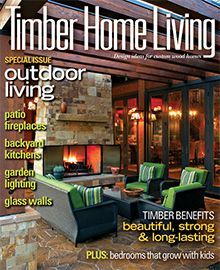 The cover of a timber home living magazine with a fireplace on it.