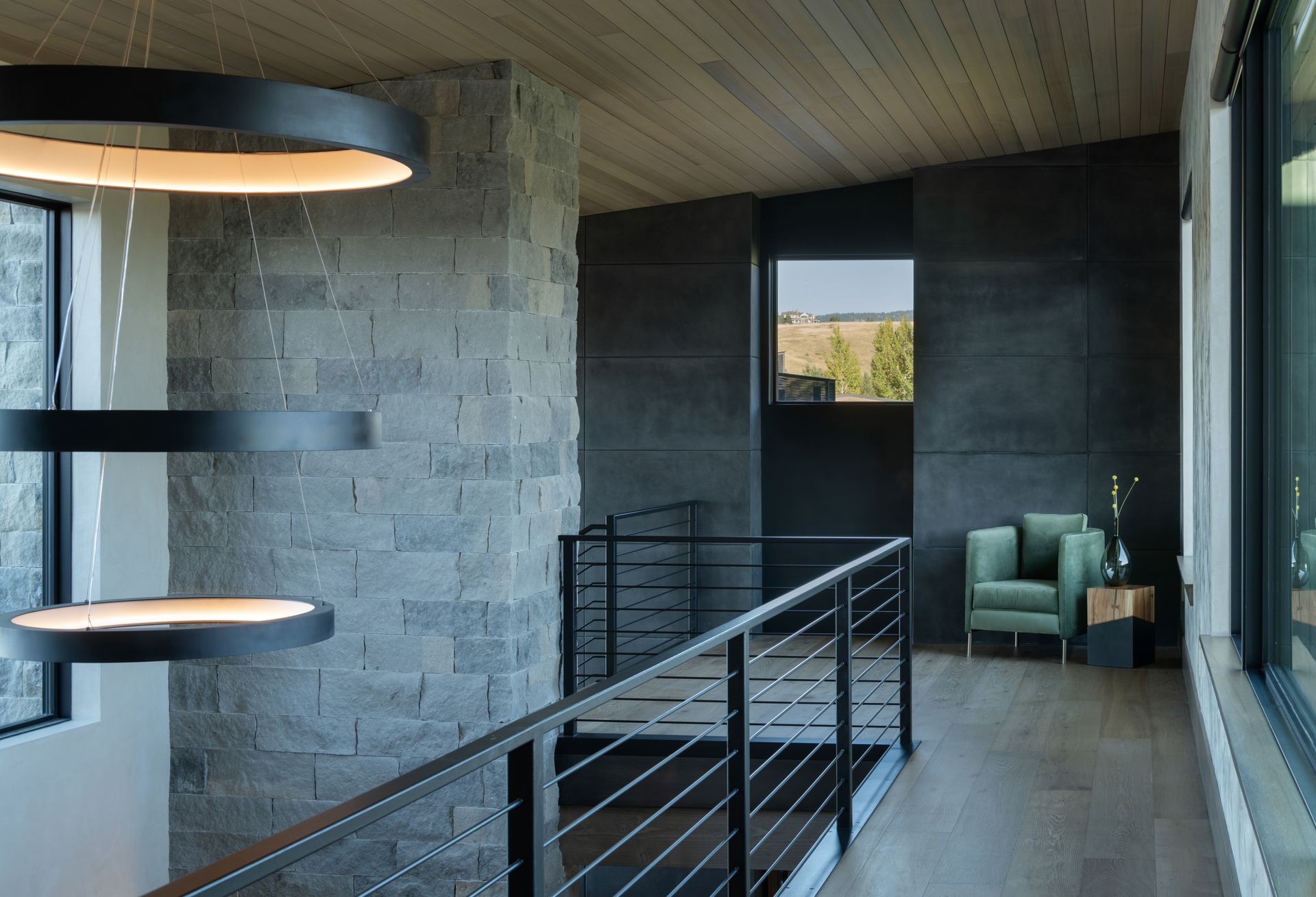A hallway with a railing and a chair in it