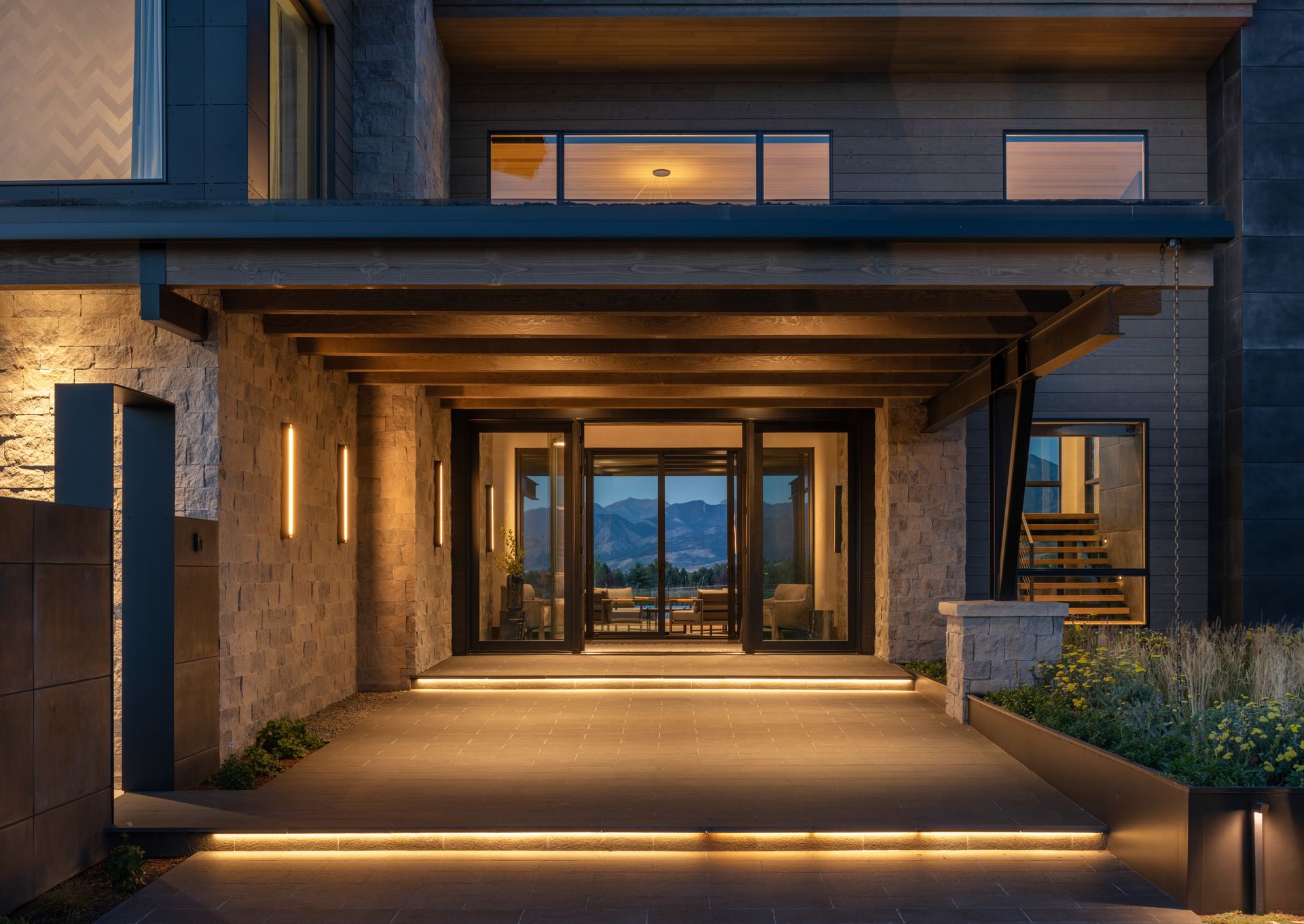 The entrance to a large house is lit up at night.