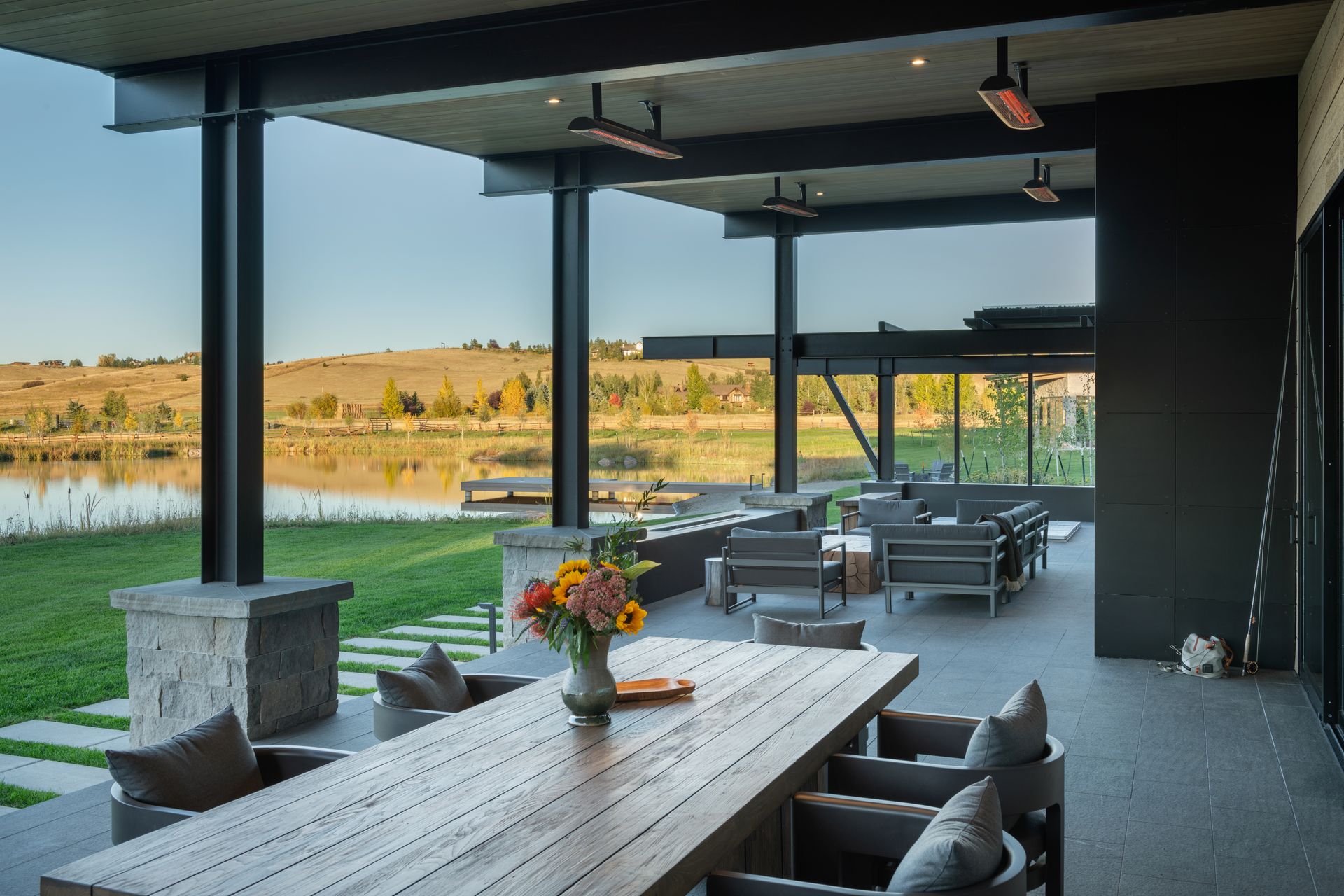 There is a large table with a vase of flowers on it in the middle of the room.