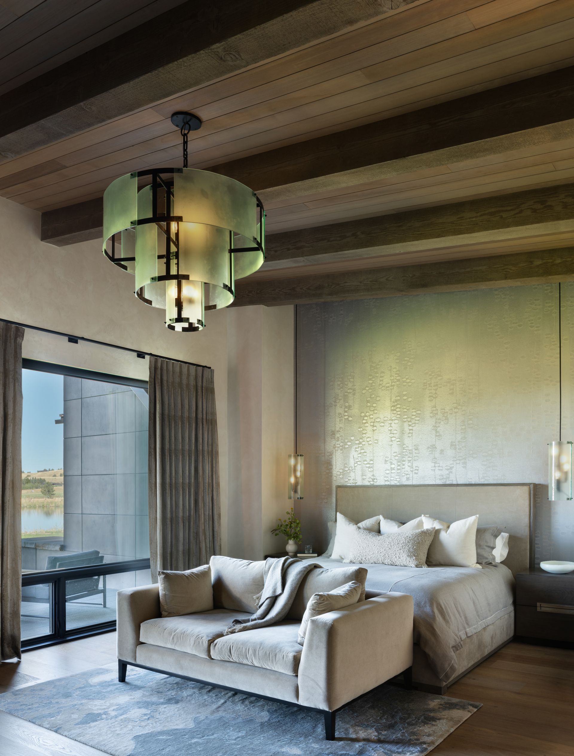 A bedroom with a couch a bed and a chandelier