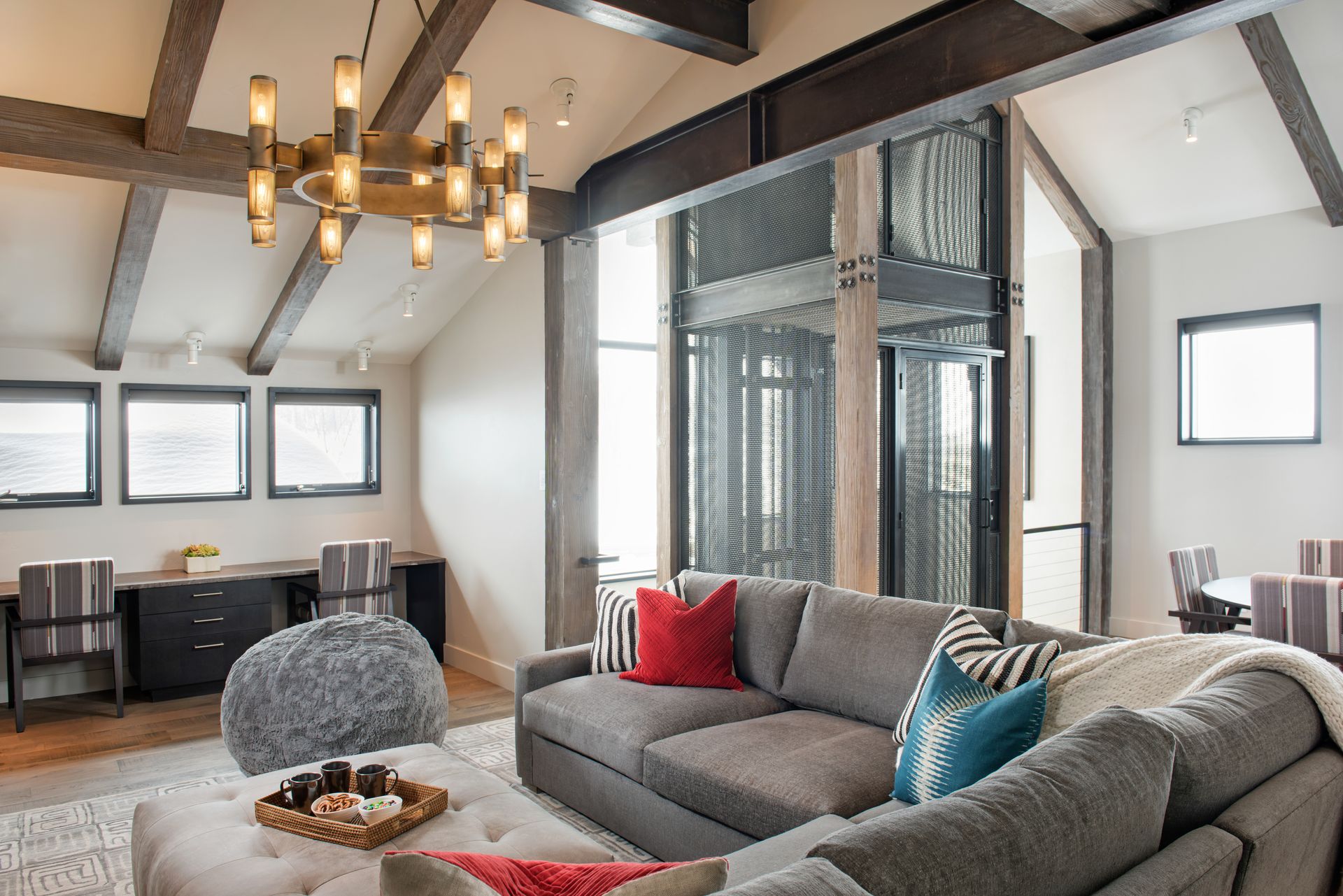A living room with a large sectional couch and a chandelier.