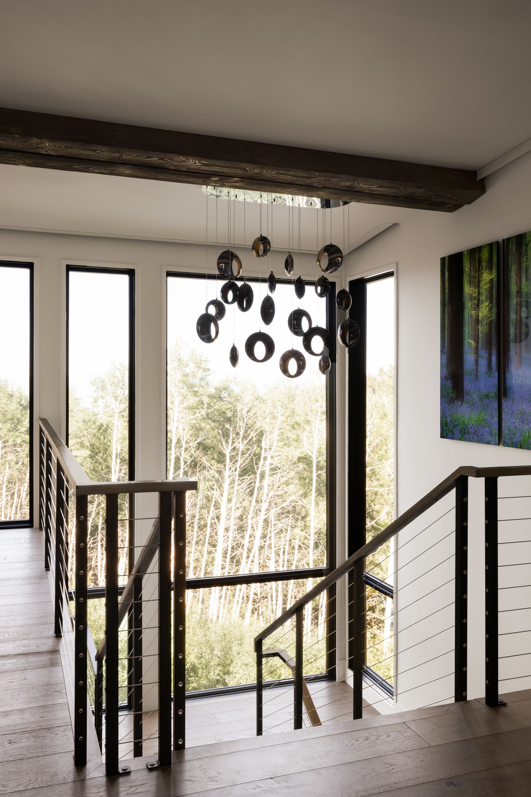 A staircase in a house with a chandelier hanging from the ceiling.