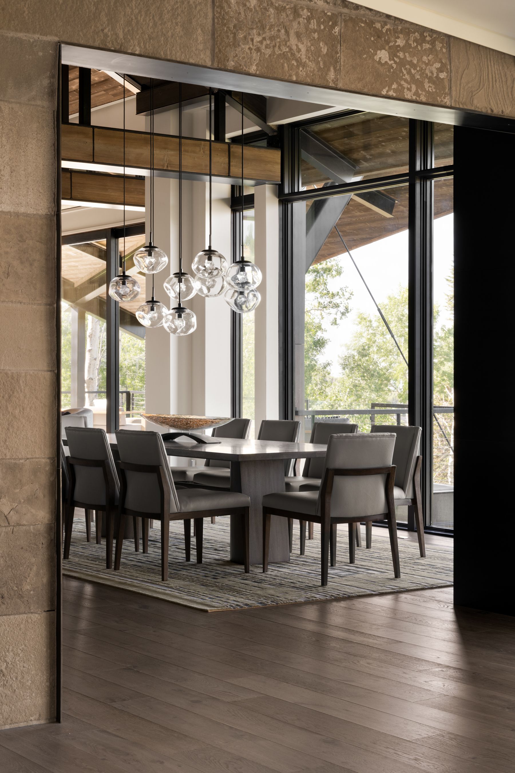 A dining room with a table and chairs and a large window.