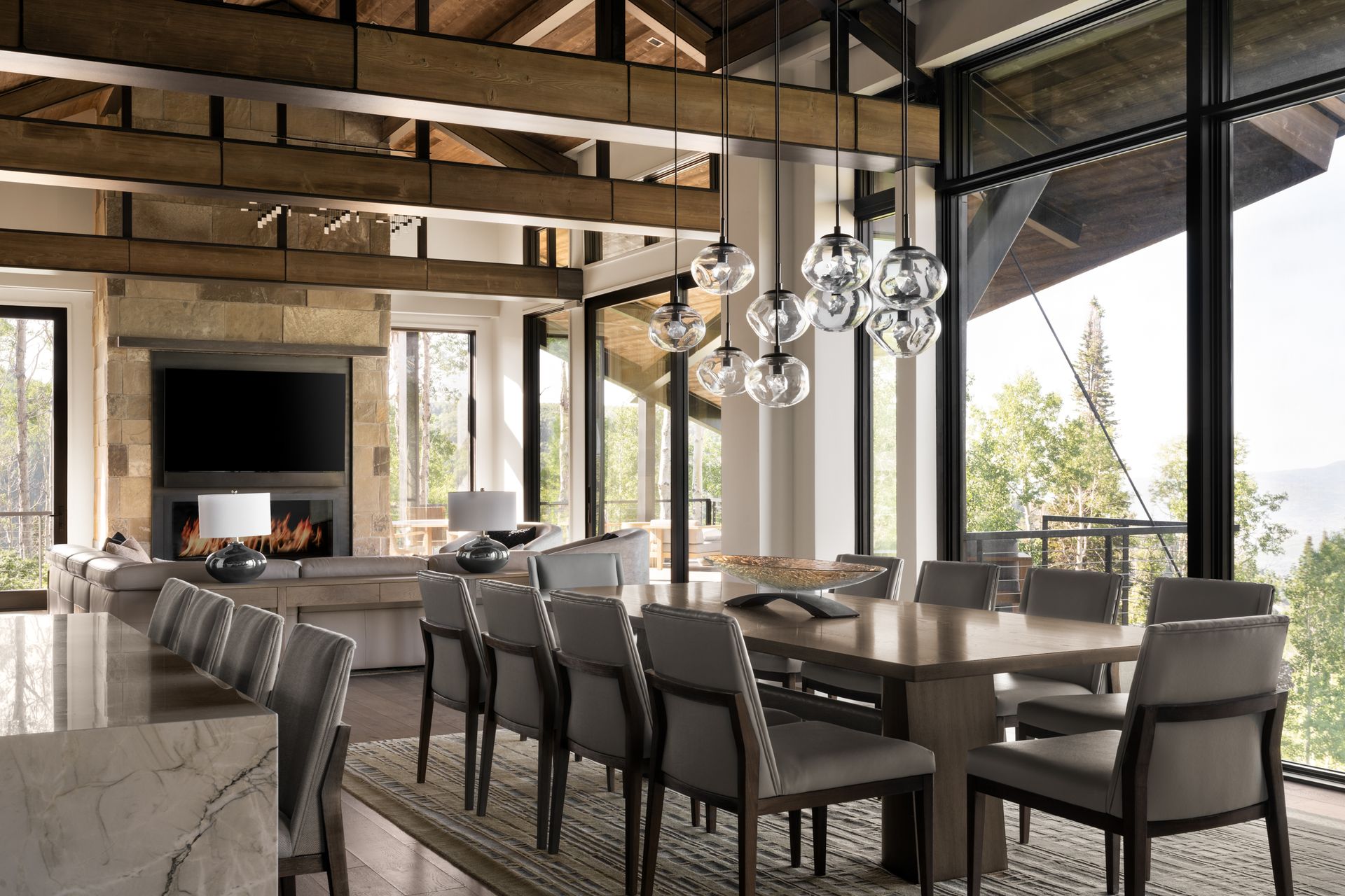 A dining room with a long table and chairs and a fireplace.