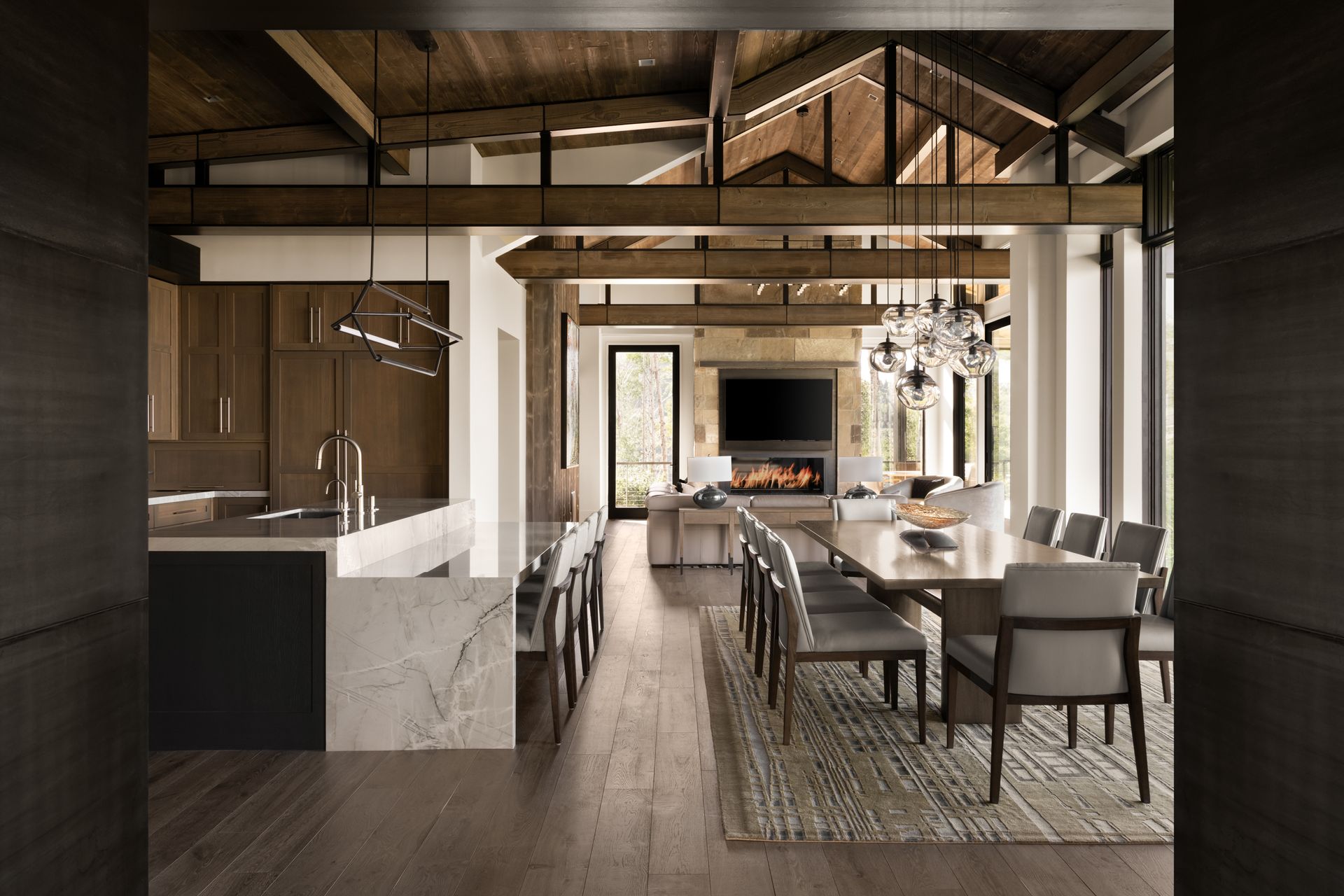 A kitchen and dining room in a large house with wooden beams.