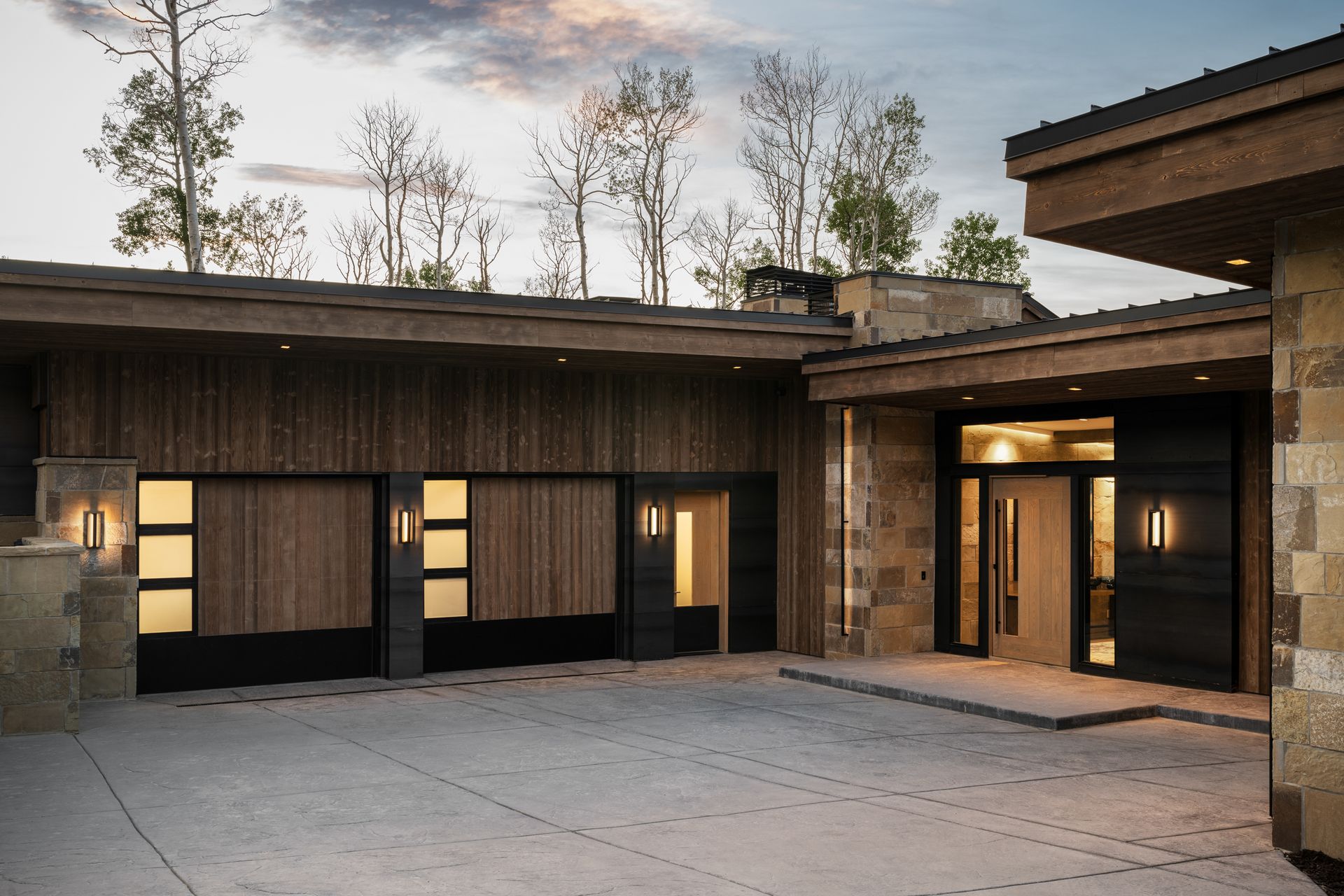A modern house with a large garage and a large driveway.