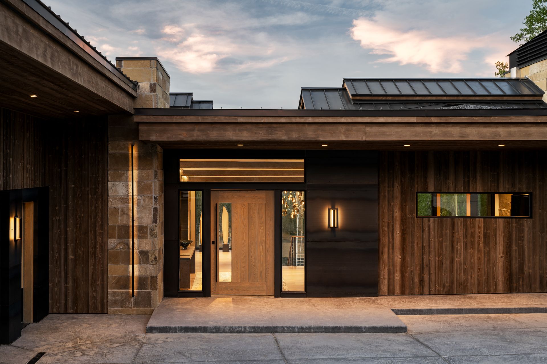 A modern house with a wooden facade and a black door.