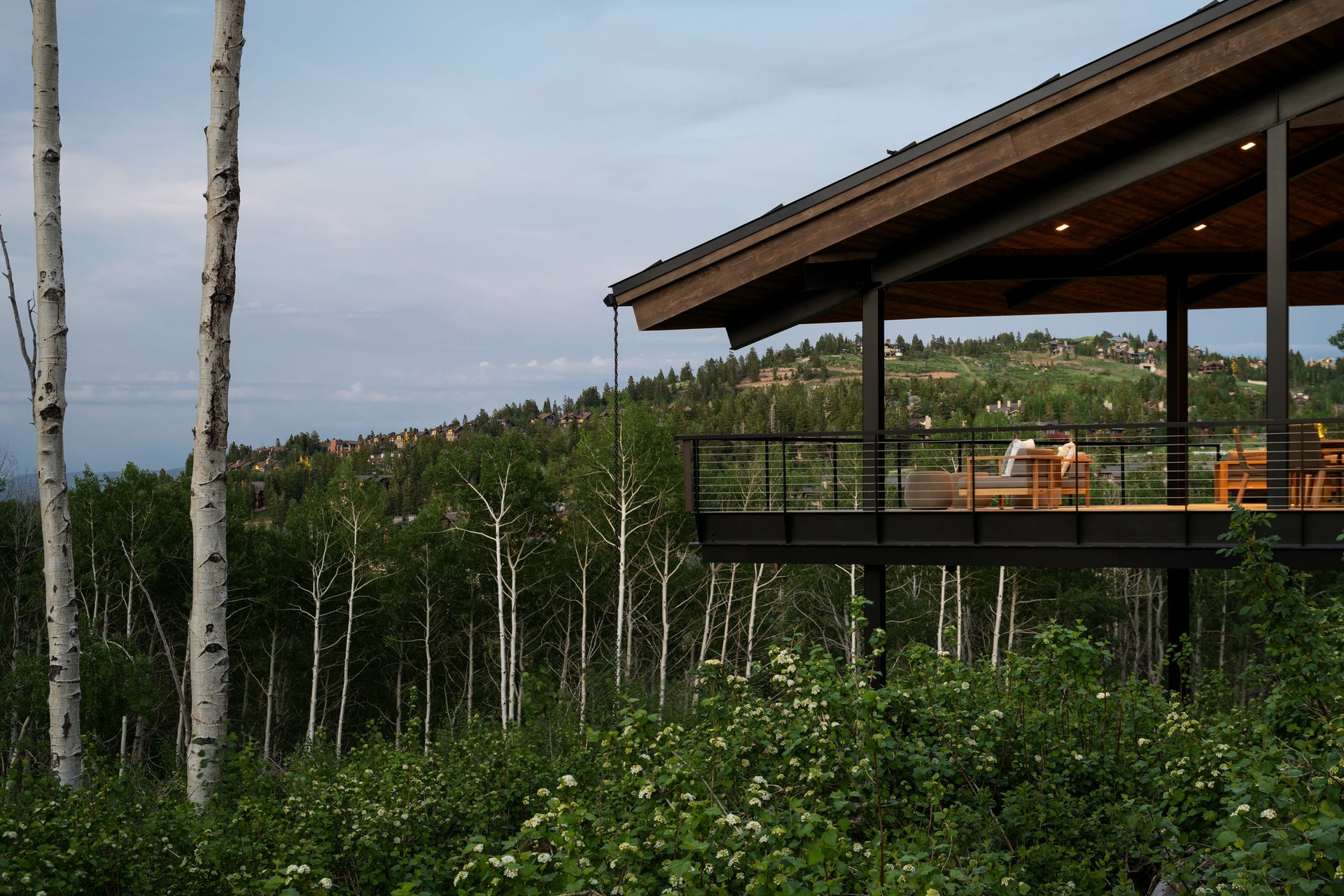 A house with a balcony in the middle of a forest