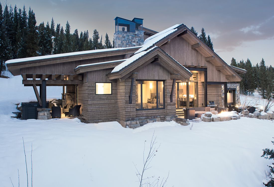A log cabin is sitting in the middle of a snow covered field.