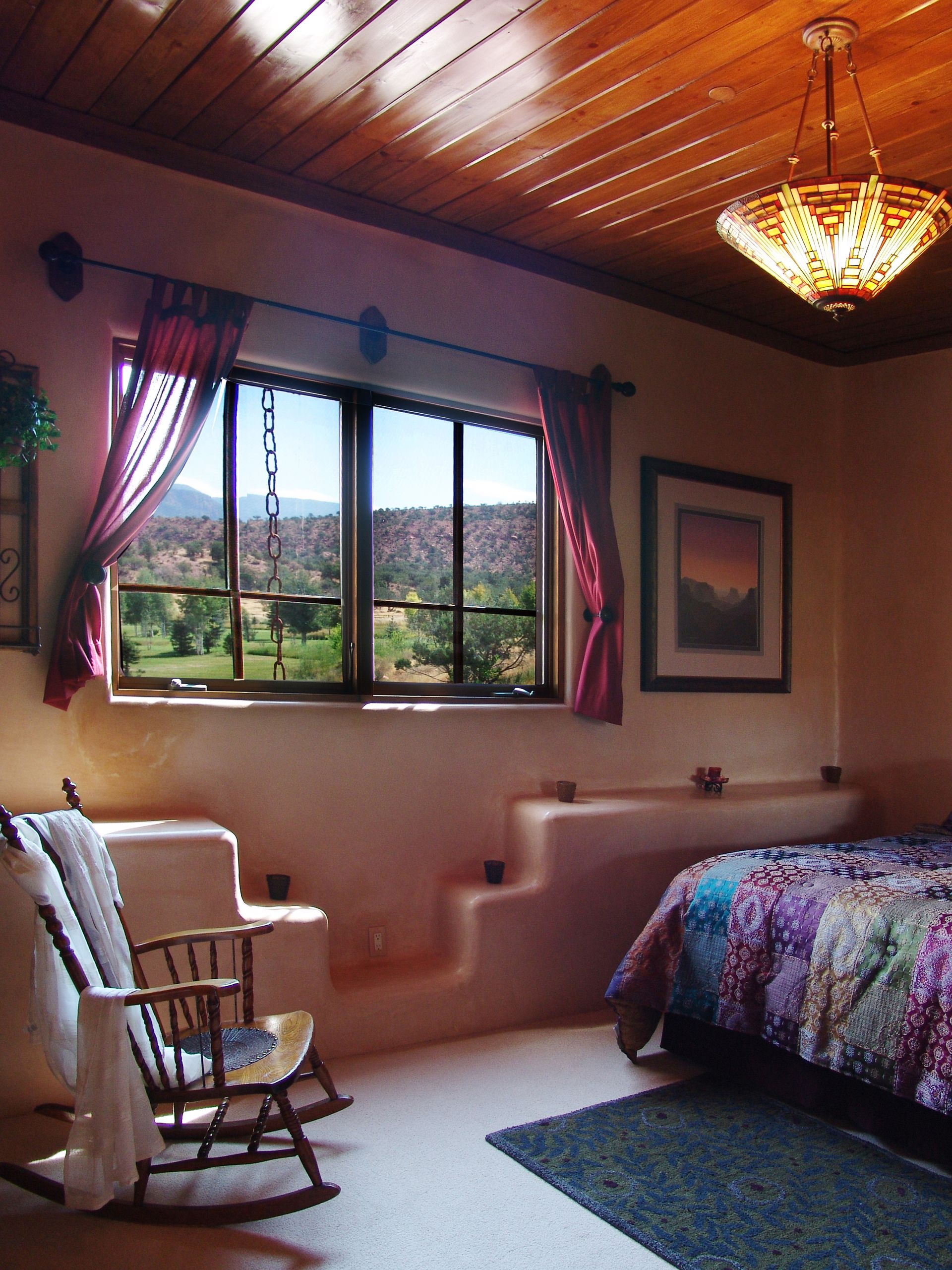 A bedroom with a rocking chair and a bed