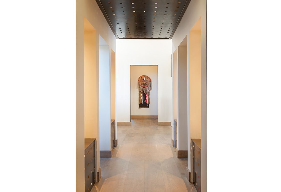 A long hallway in a house with a painting on the wall.